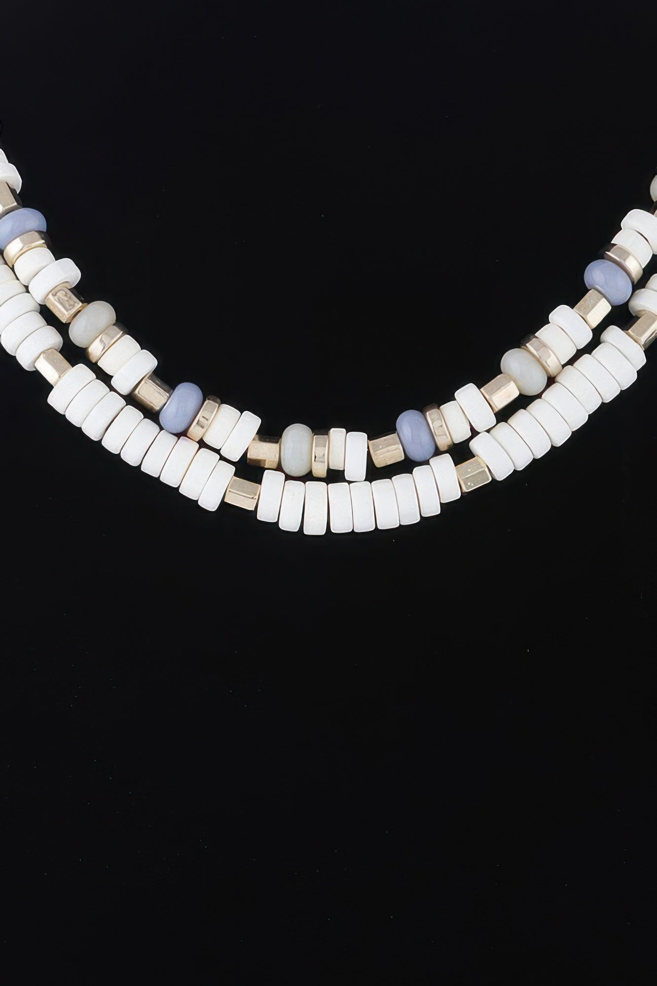 Close-up layered disk necklace: white beads with pale blue pieces and gold spacers