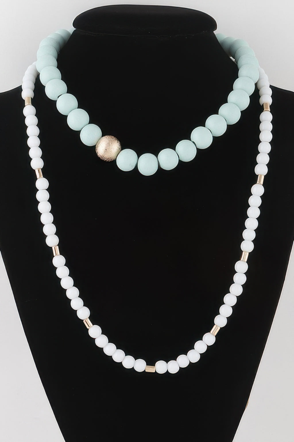 Two-toned long beaded necklace in light blue and white beads with gold center bead