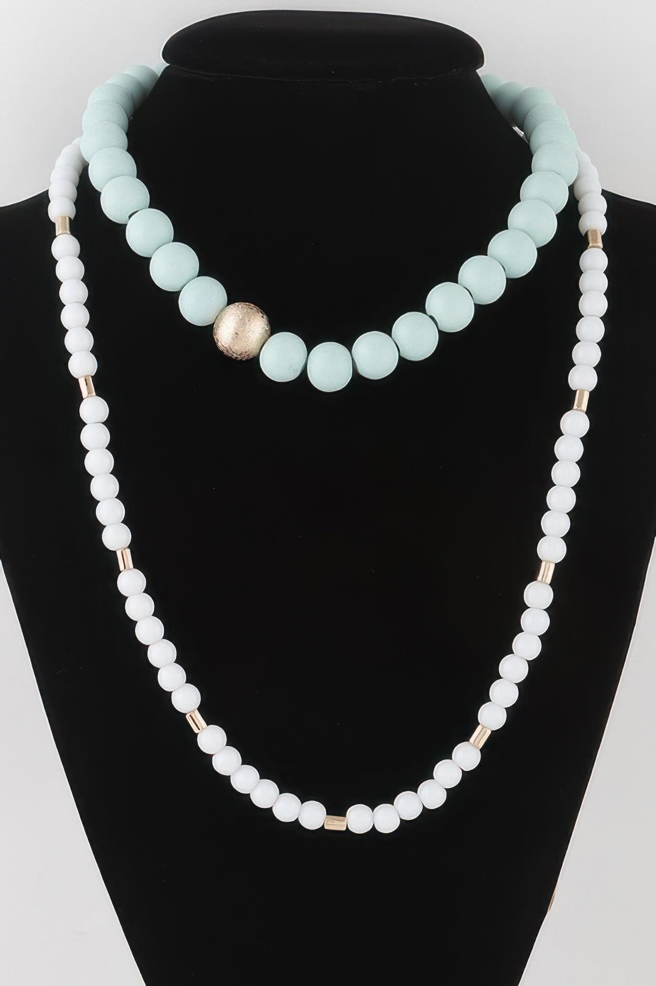 Two-toned long beaded necklace in light blue and white beads with gold center bead