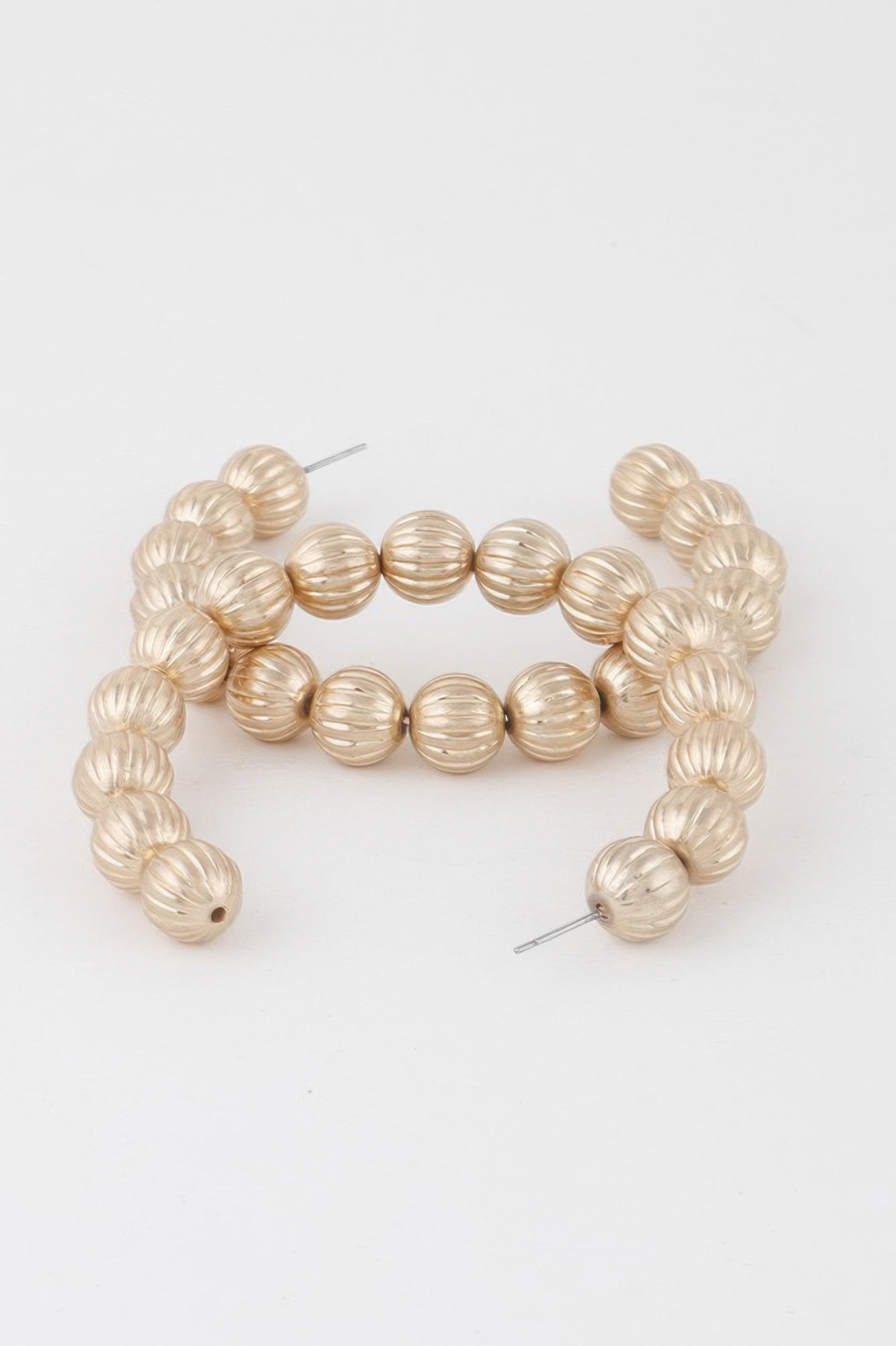 Gold beaded hoop earrings with ribbed oval beads and small post backs