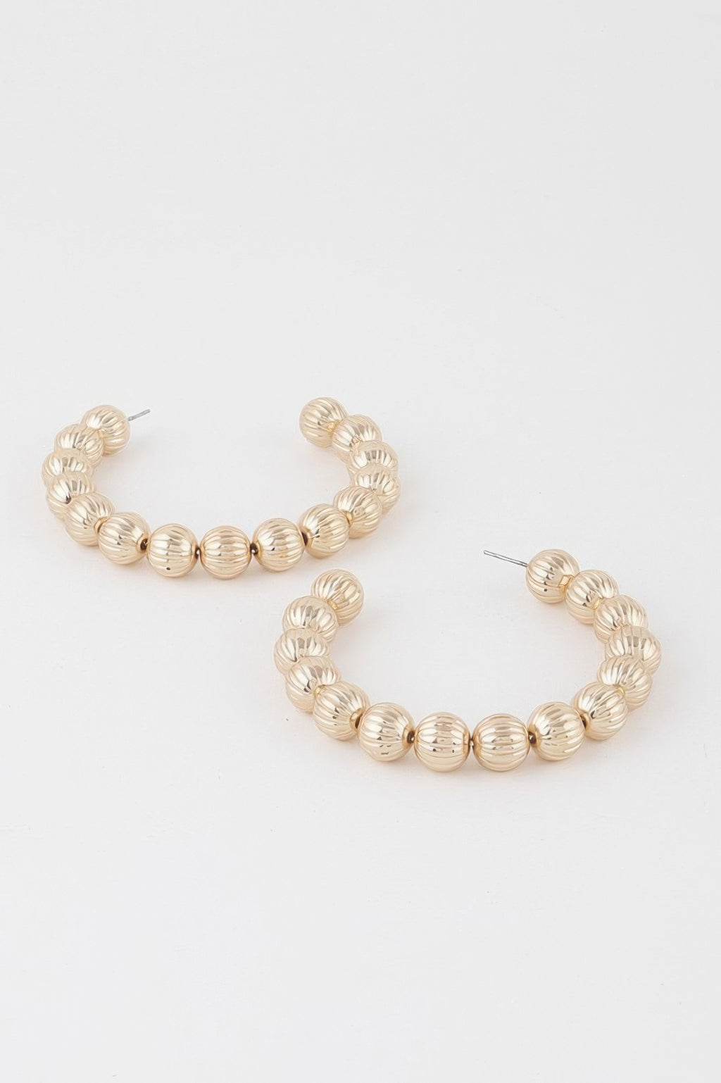 Pair of gold beaded hoop earrings with sculpted ribbed bead segments