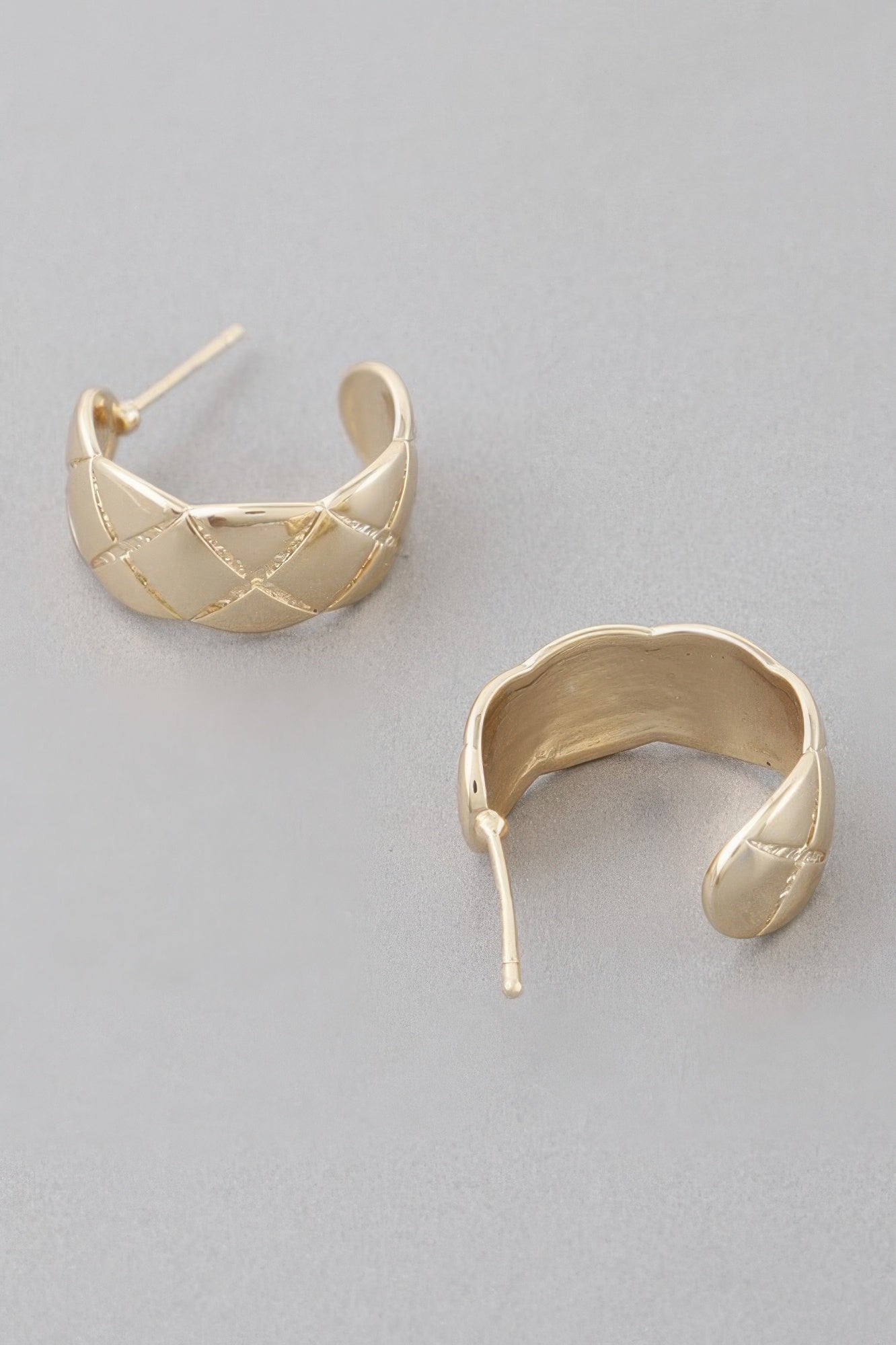 Gold diamond-cut hoop earrings showing inside curve and triangular stitched pattern
