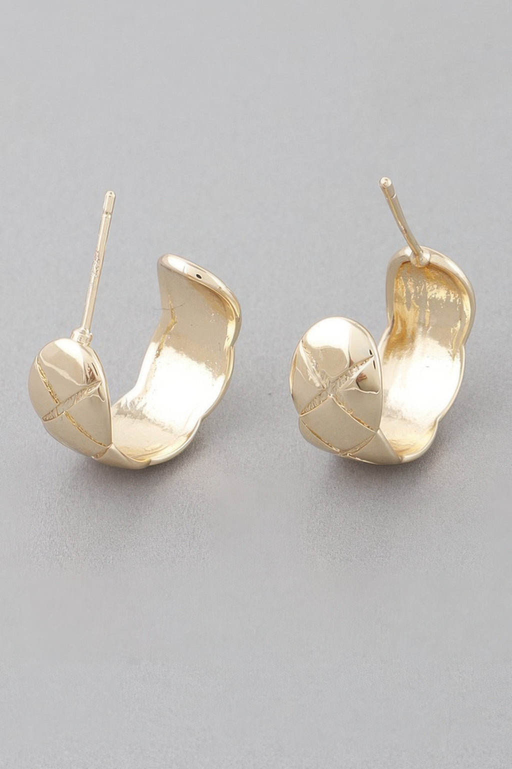Gold diamond-cut hoop earrings with polished open crescent and textured faceted panels