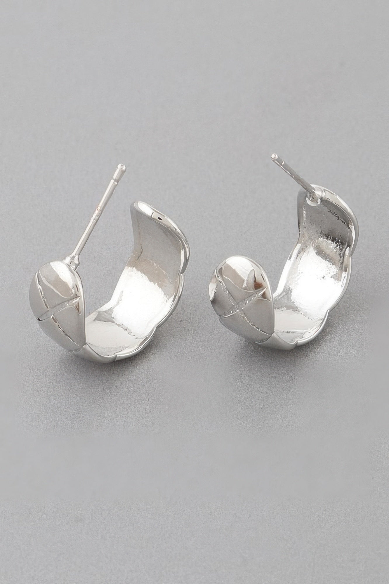 Silver diamond-cut hoop earrings with faceted triangular detailing and hinged post backs