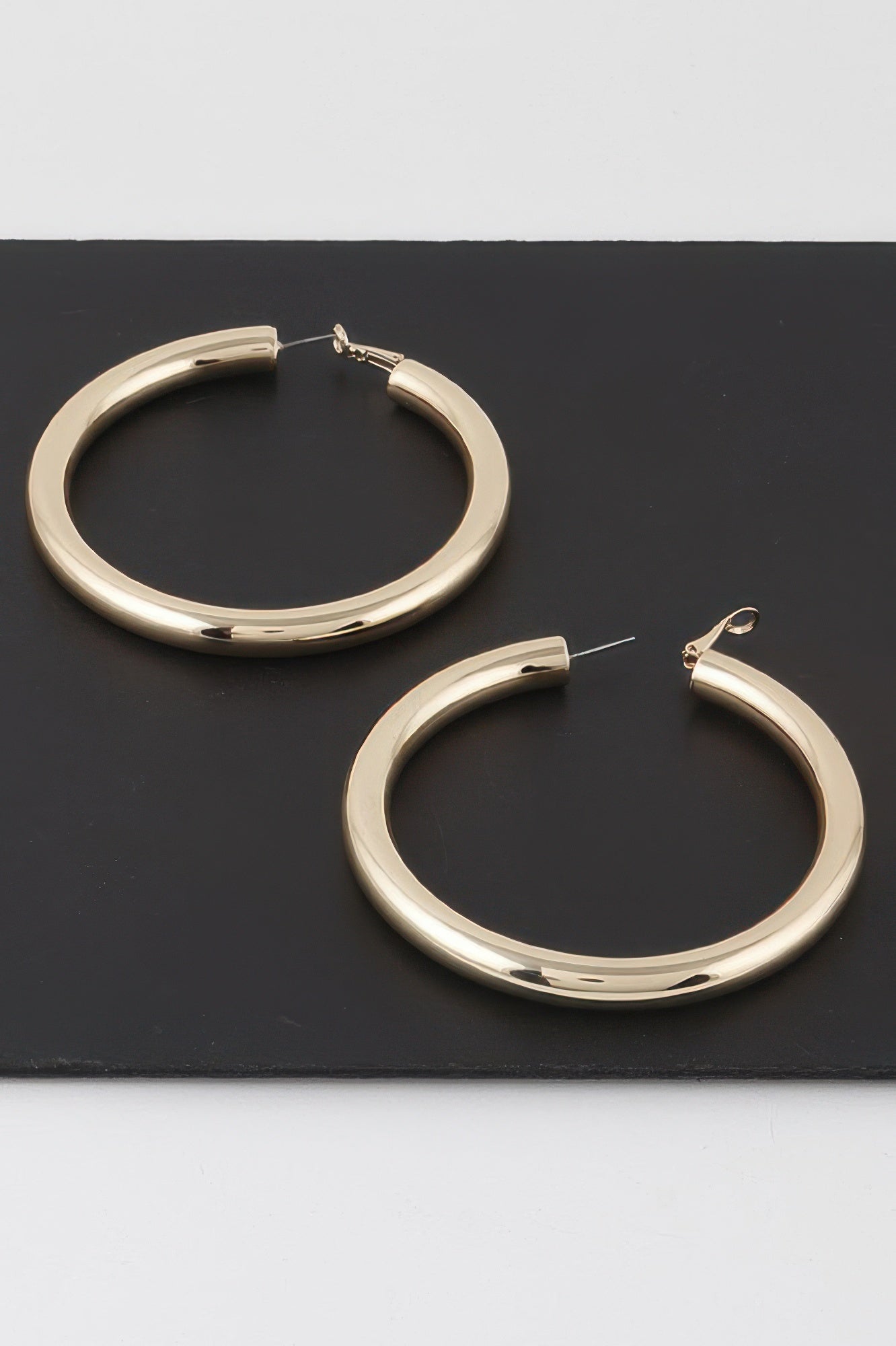 Pair of gold sleek tube hoop earrings, circular thick hoops with post backs