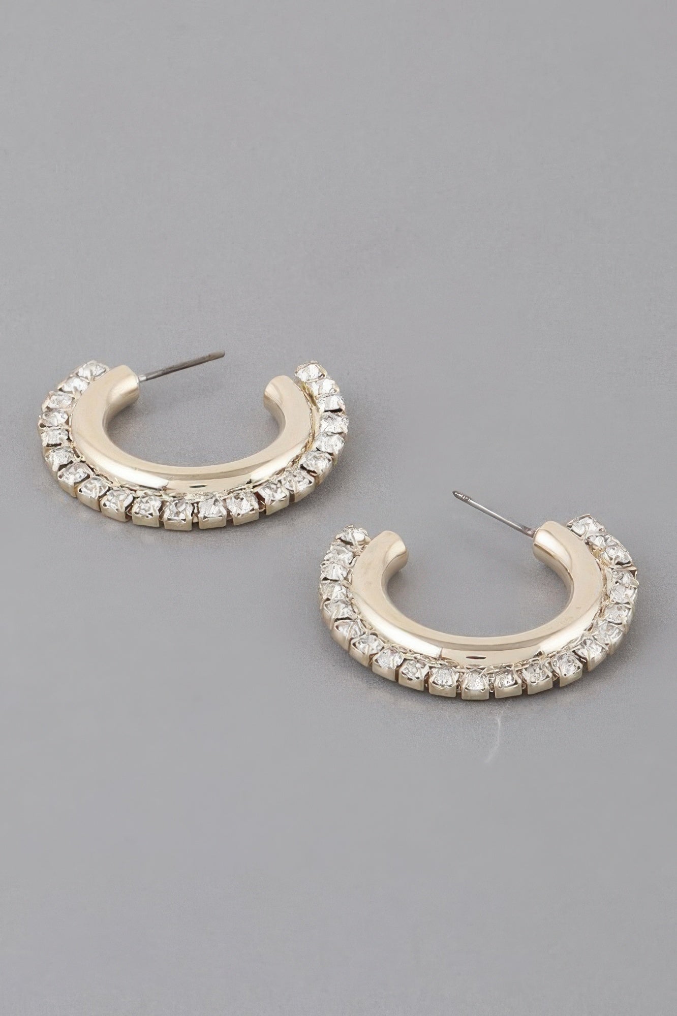 Gold hoop earrings with clear rhinestone lining, oval huggie style