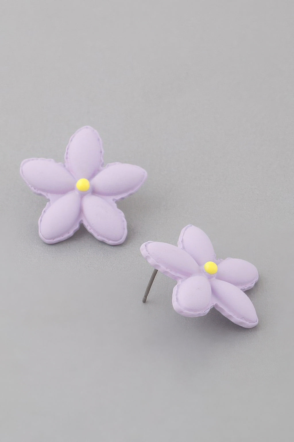 Lavender flower stud earrings, one earring post visible; yellow flower center