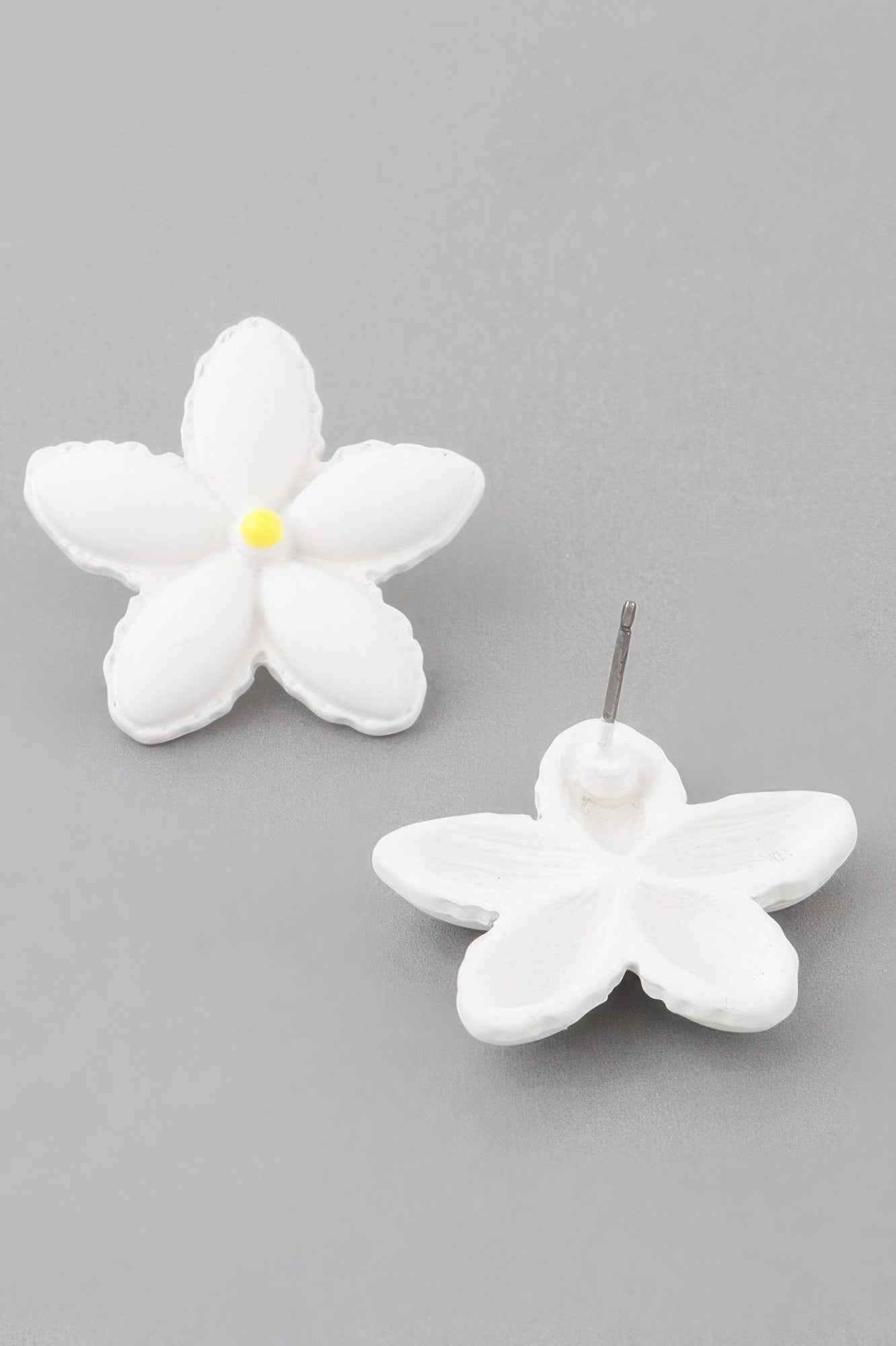 White flower stud earrings with yellow center, metal post on one earring