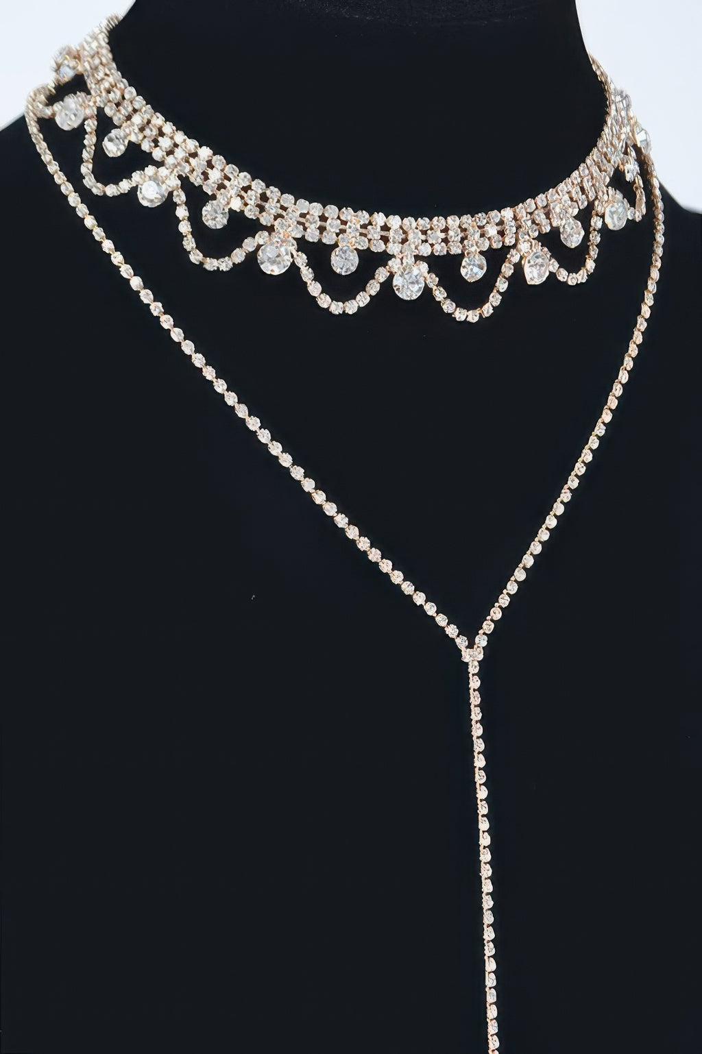 Rhinestone necklace detail view: scalloped choker with heart-like settings, gold tone