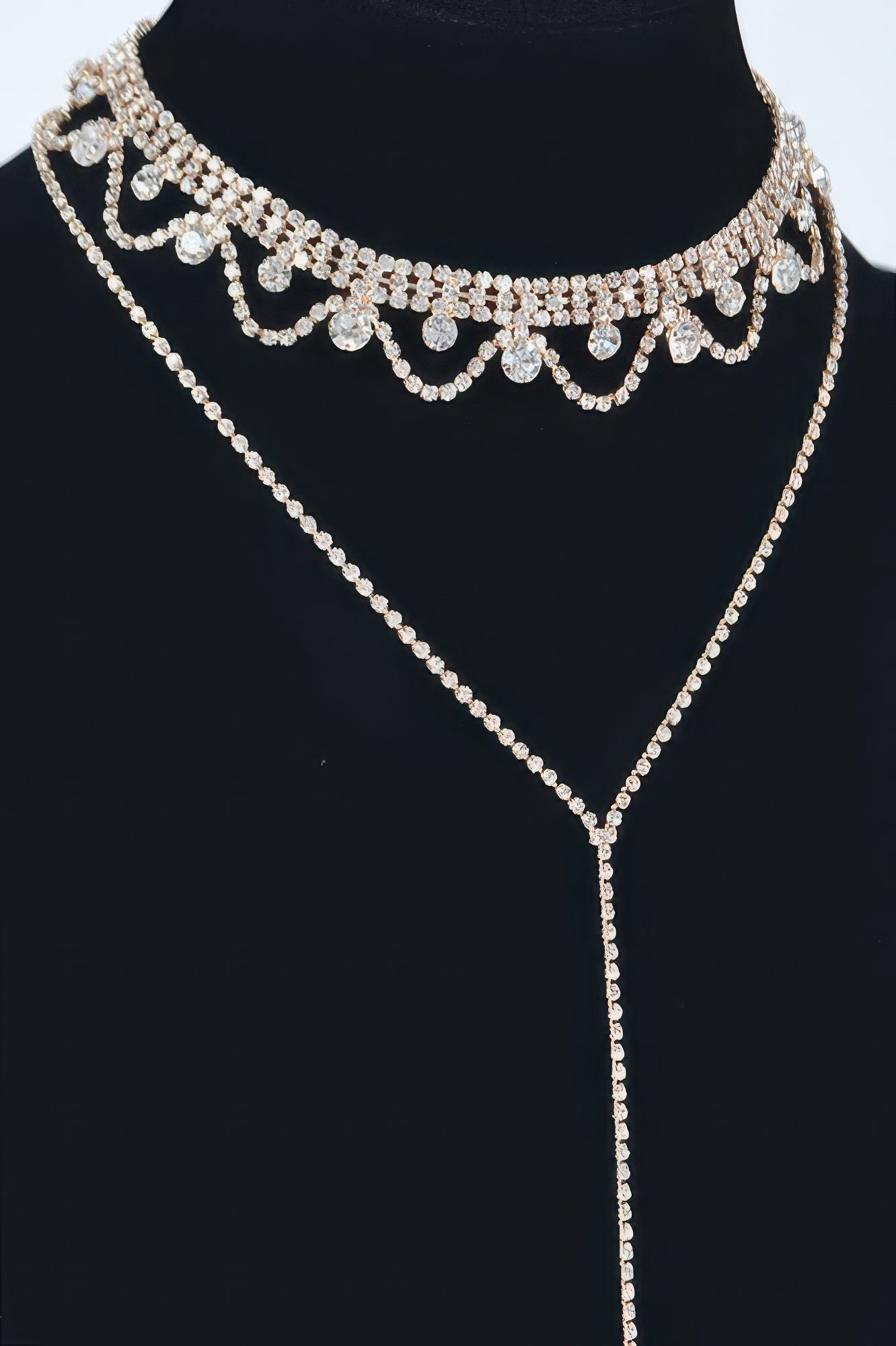 Rhinestone necklace detail view: scalloped choker with heart-like settings, gold tone