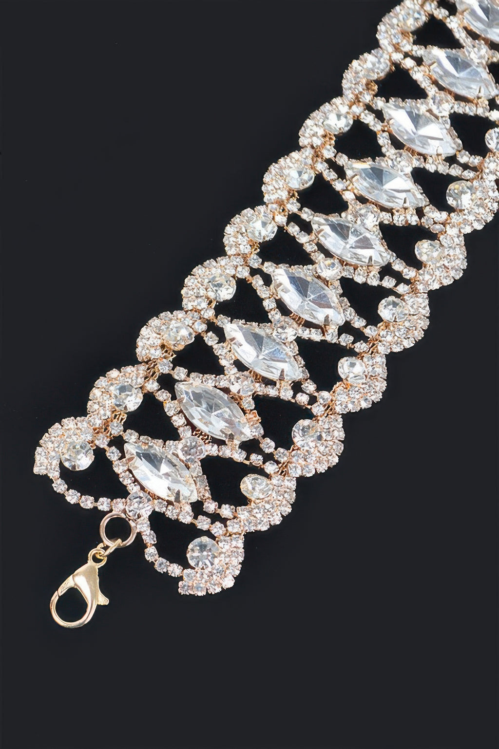 Close-up silver rhinestone tennis necklace with marquise drops and halo settings.