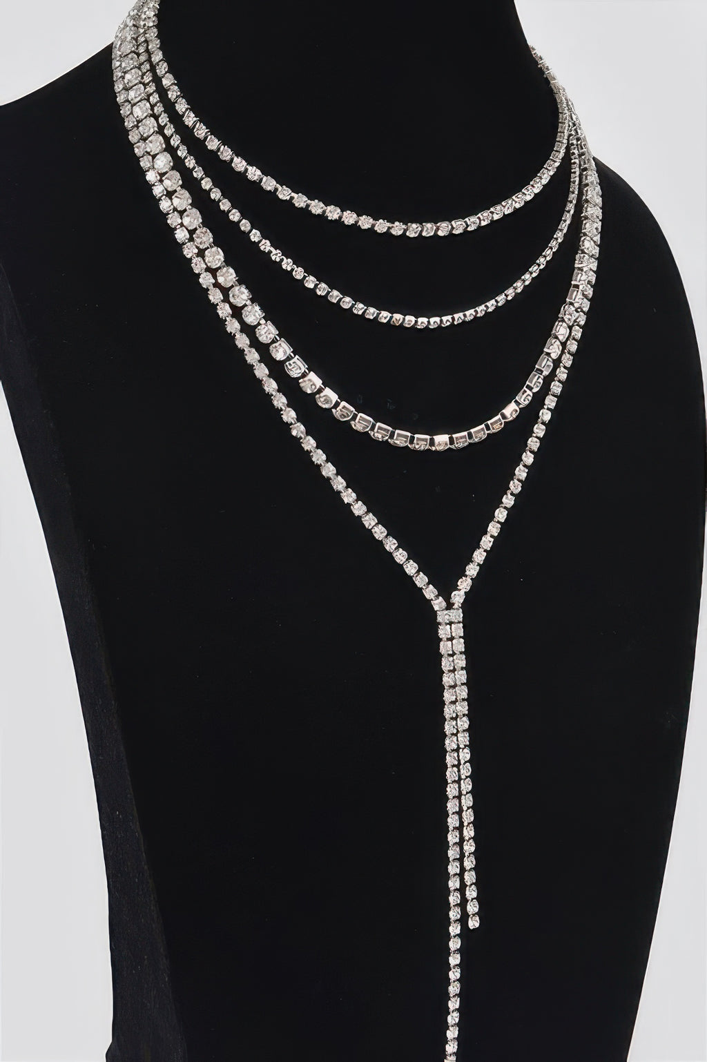 Gold-tone multi-layer rhinestone necklace with 3 curved rows and long vertical drop