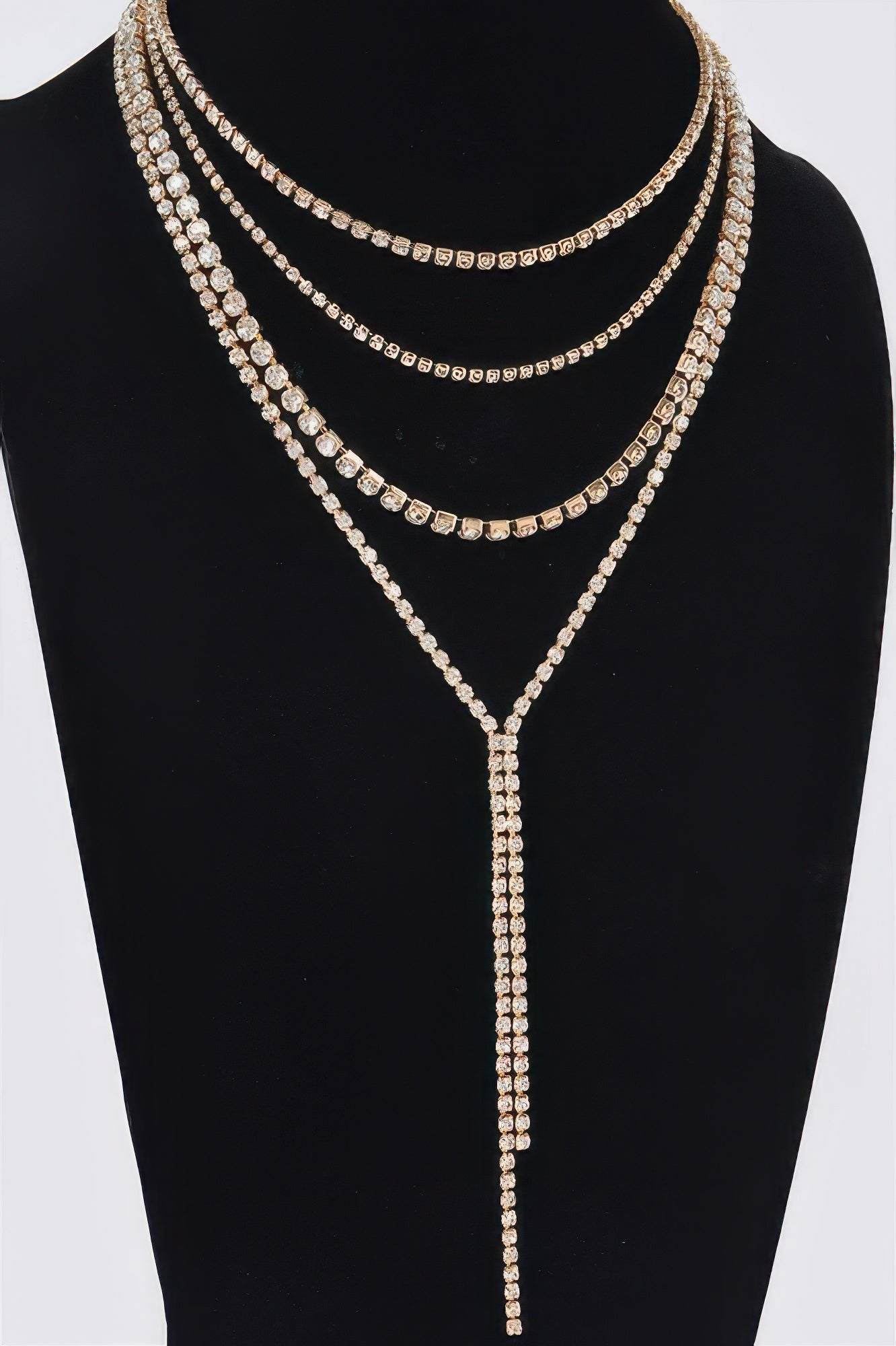 Gold-tone multi-row rhinestone necklace with teardrop center and long hanging tassel
