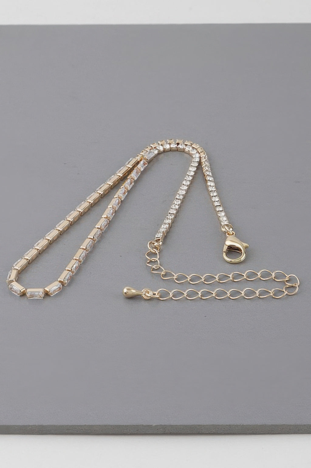 Gold-toned cubic crystal jewel necklace with heart lobster clasp and extender chain