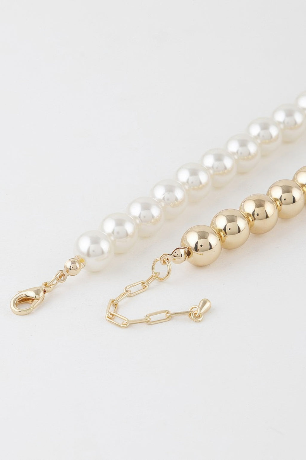 Close-up of two-toned beaded necklace clasp with cream and gold beads