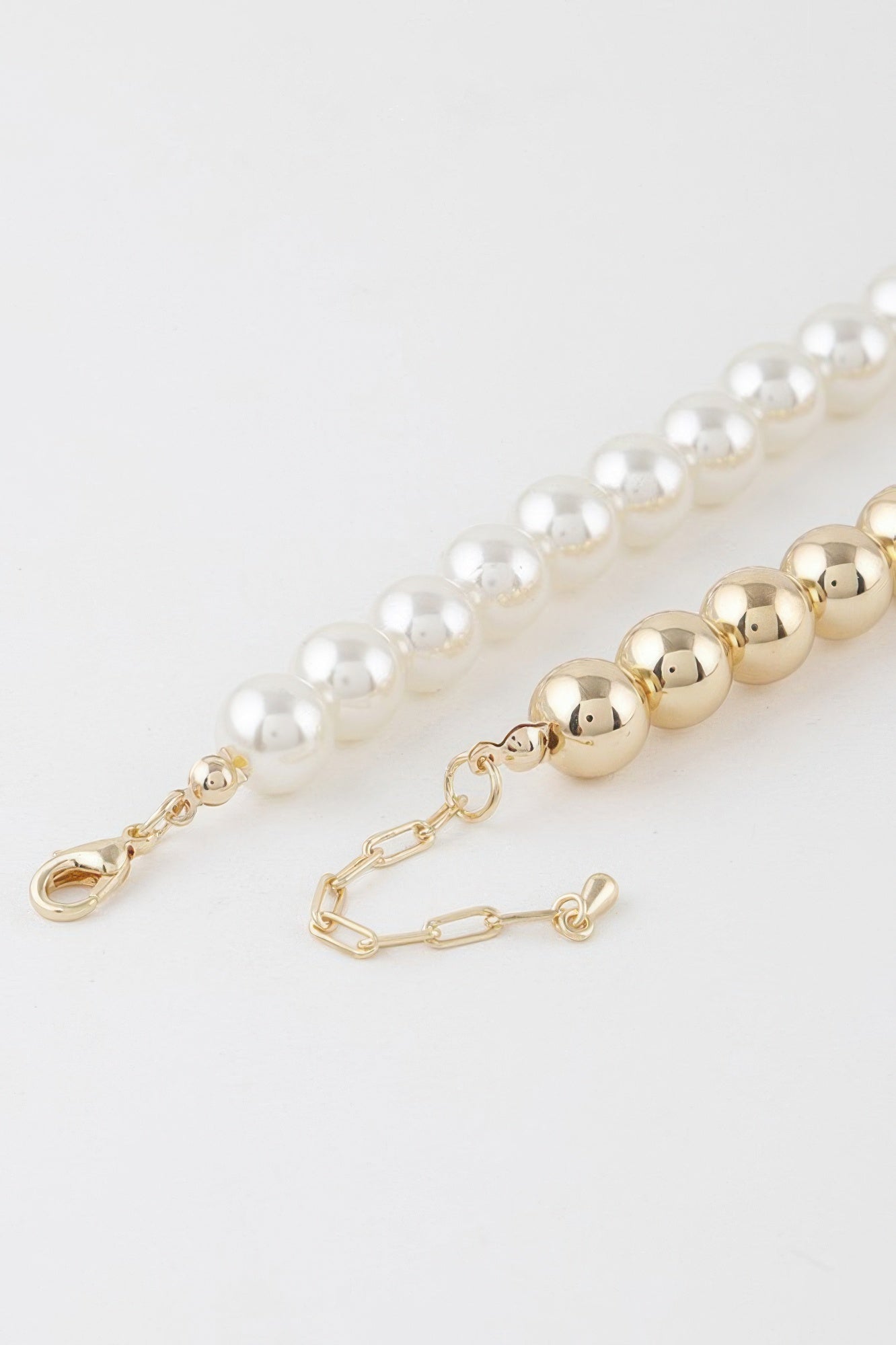 Close-up of two-toned beaded necklace clasp with cream and gold beads