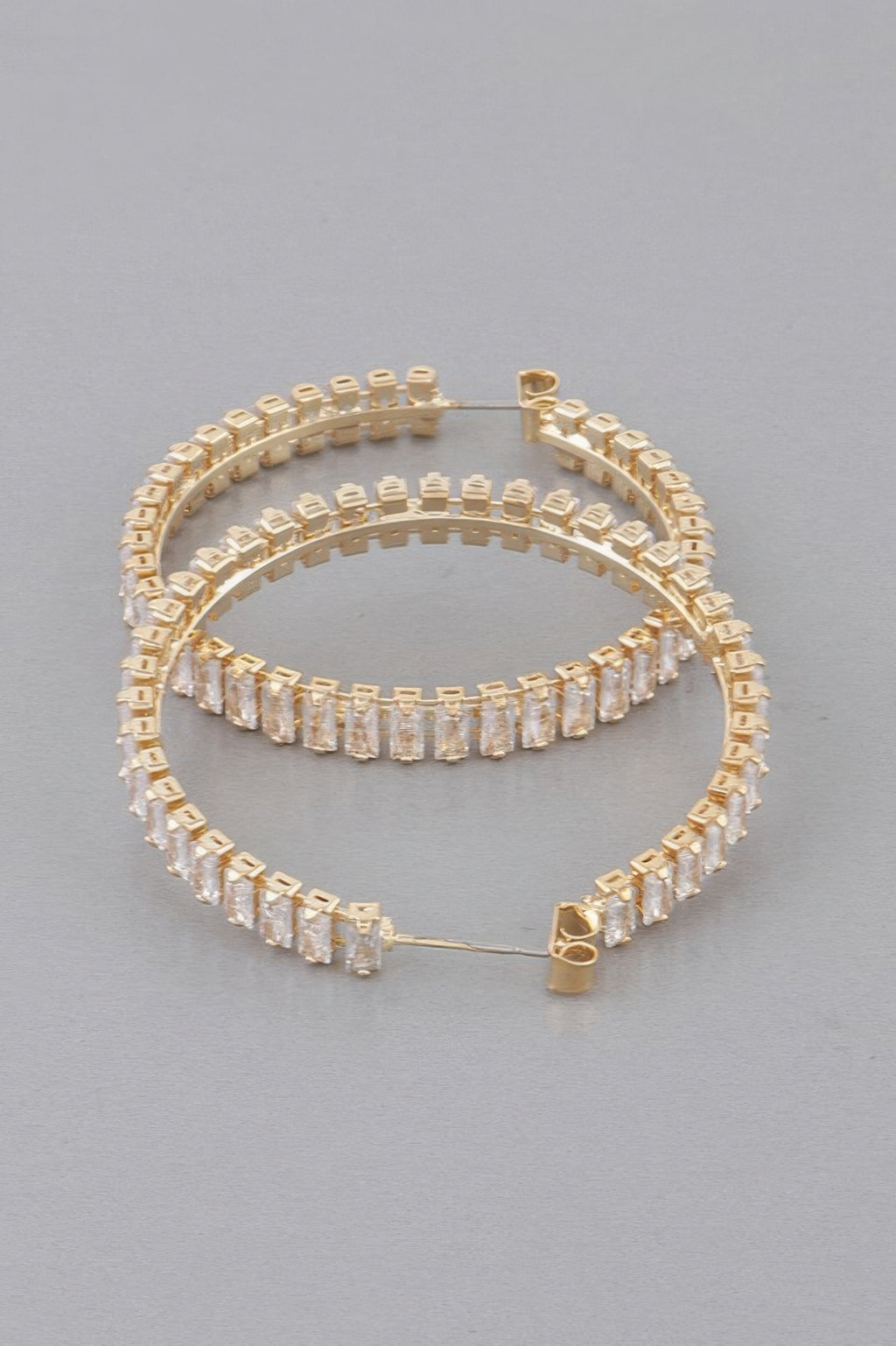 Gold hoop earrings with clear multi-row baguette rhinestones and hinged clasp