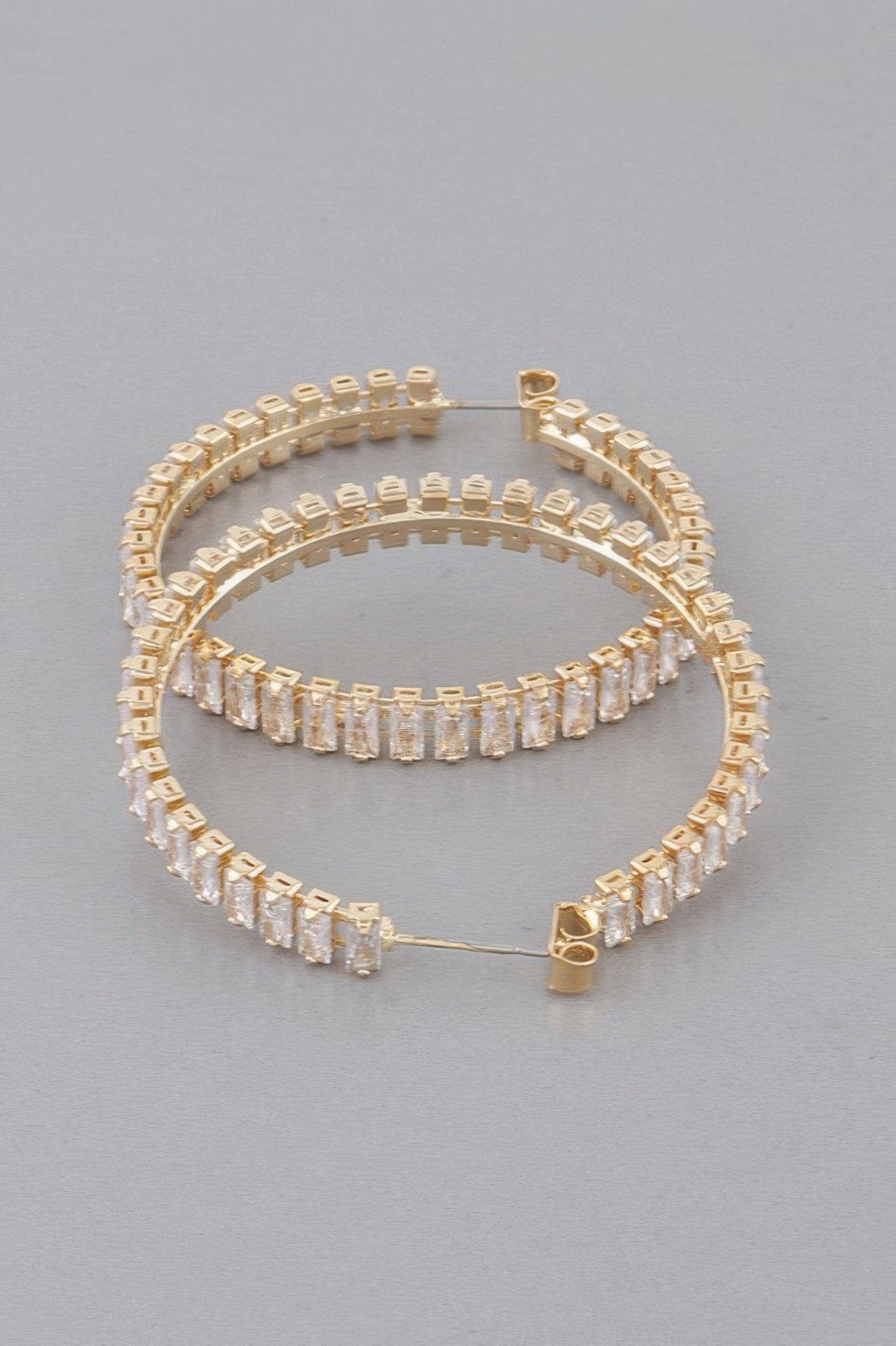 Gold hoop earrings with clear multi-row baguette rhinestones and hinged clasp