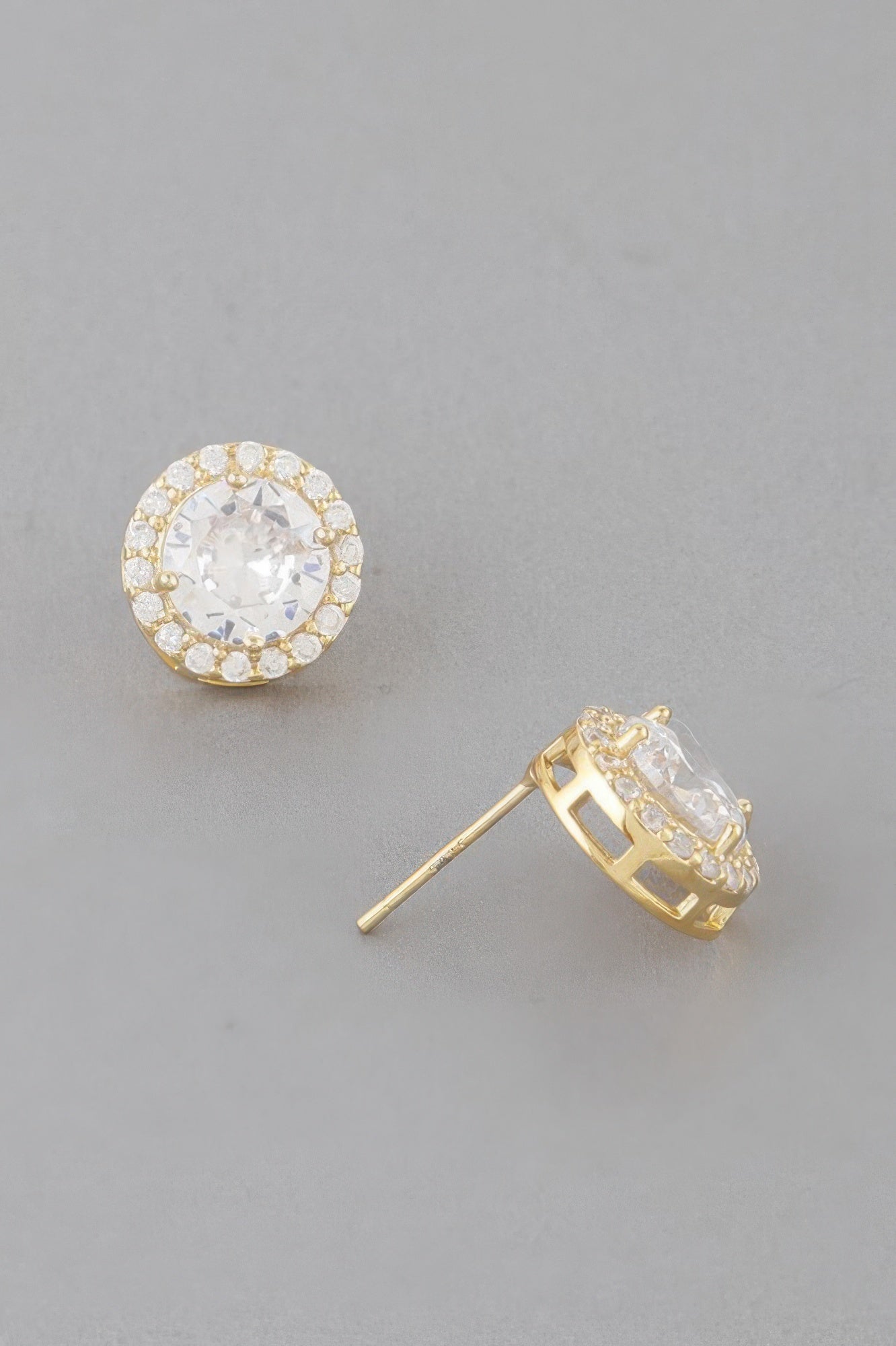 Gold stud earrings with clear round center stone and halo bezel