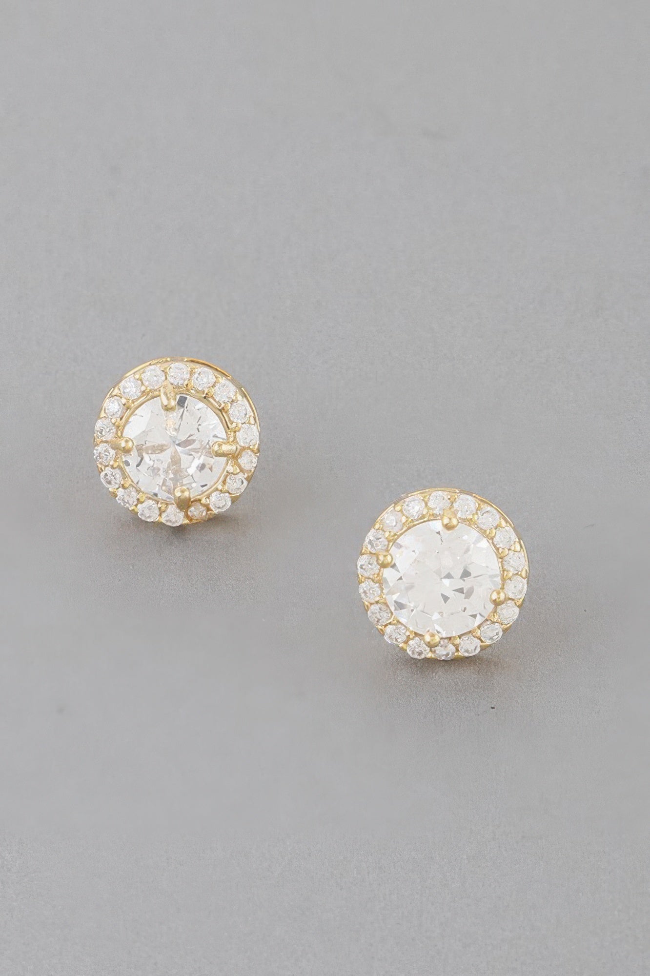 Gold round jeweled stud earrings with clear center stone and halo of crystals