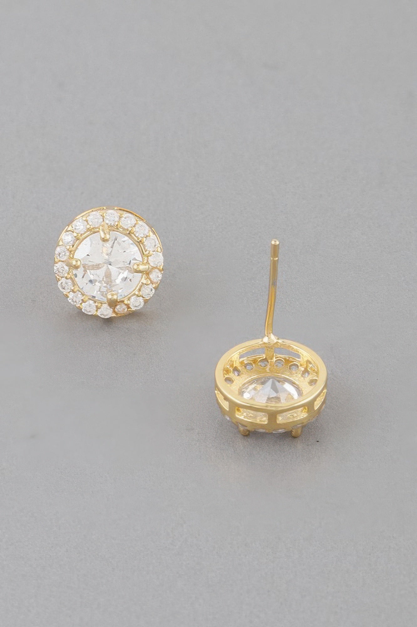 Gold round stud earring with clear center stone; circular back plate shown