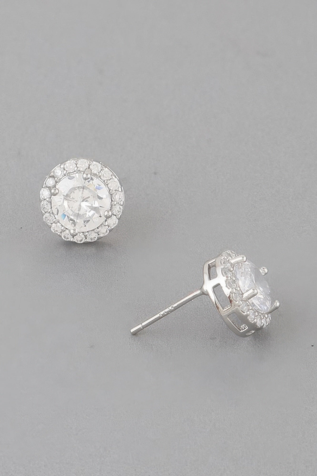 Silver round jeweled stud earrings with clear center stone and crystal halo