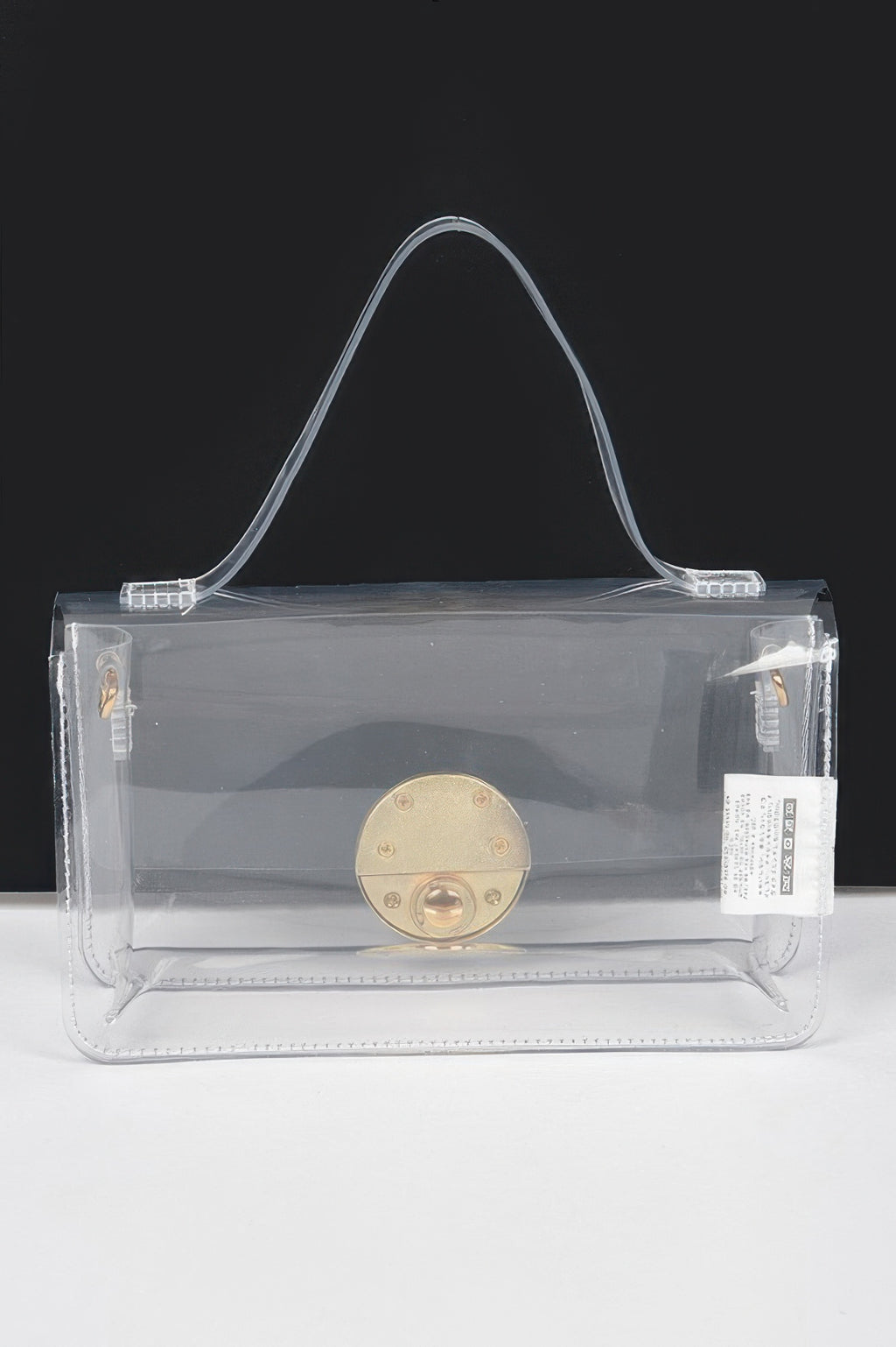 Transparent top-handle bag with clear sides, gold front clasp, and handle grips