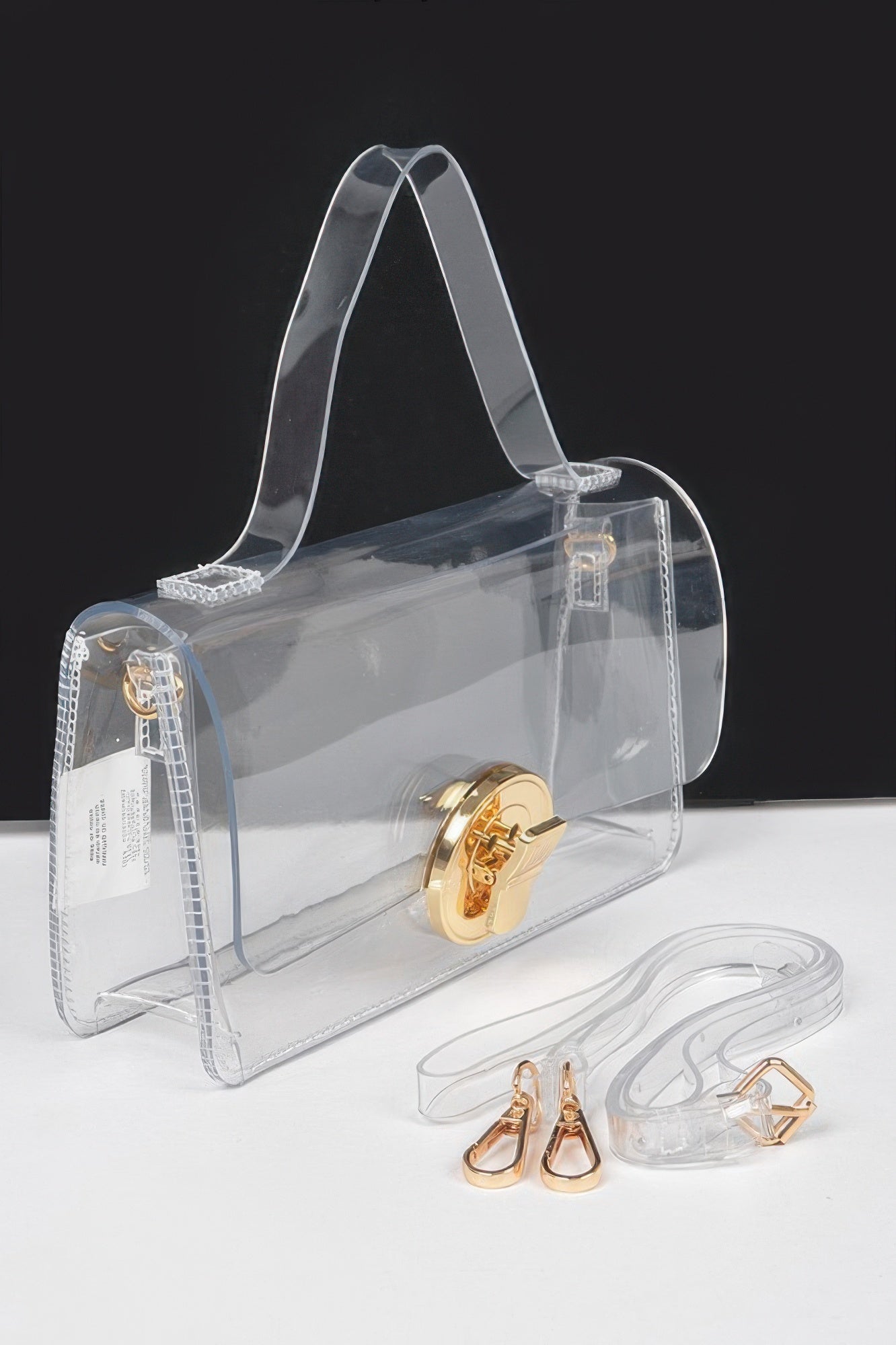 Side view of transparent top-handle bag with gold clasp and long shoulder strap