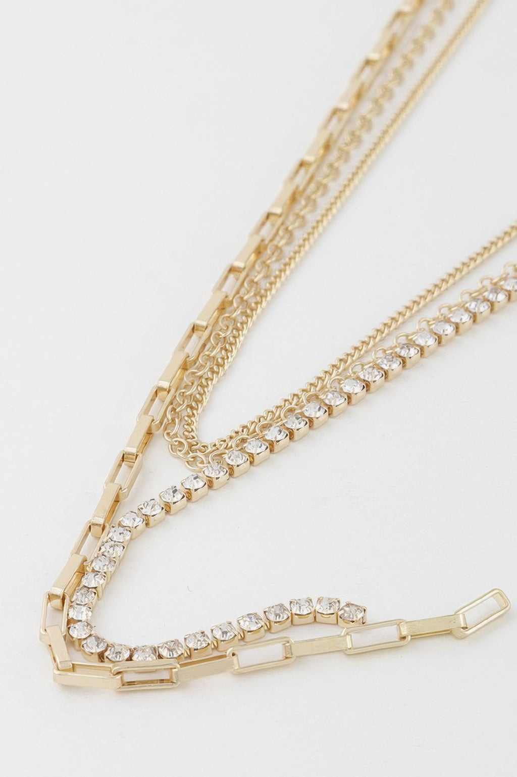 Close-up of rhinestone and chain links with rectangular bar accents, gold-tone