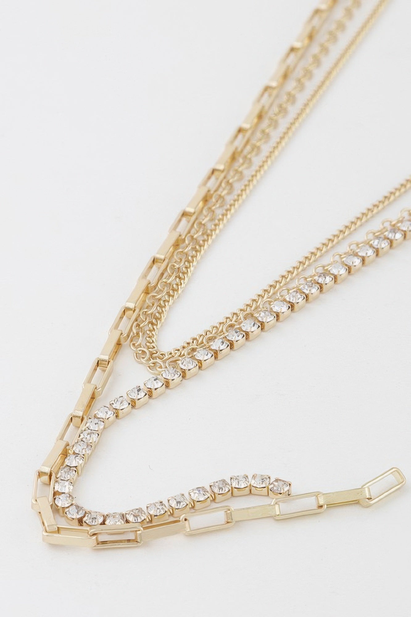 Close-up of rhinestone and chain links with rectangular bar accents, gold-tone