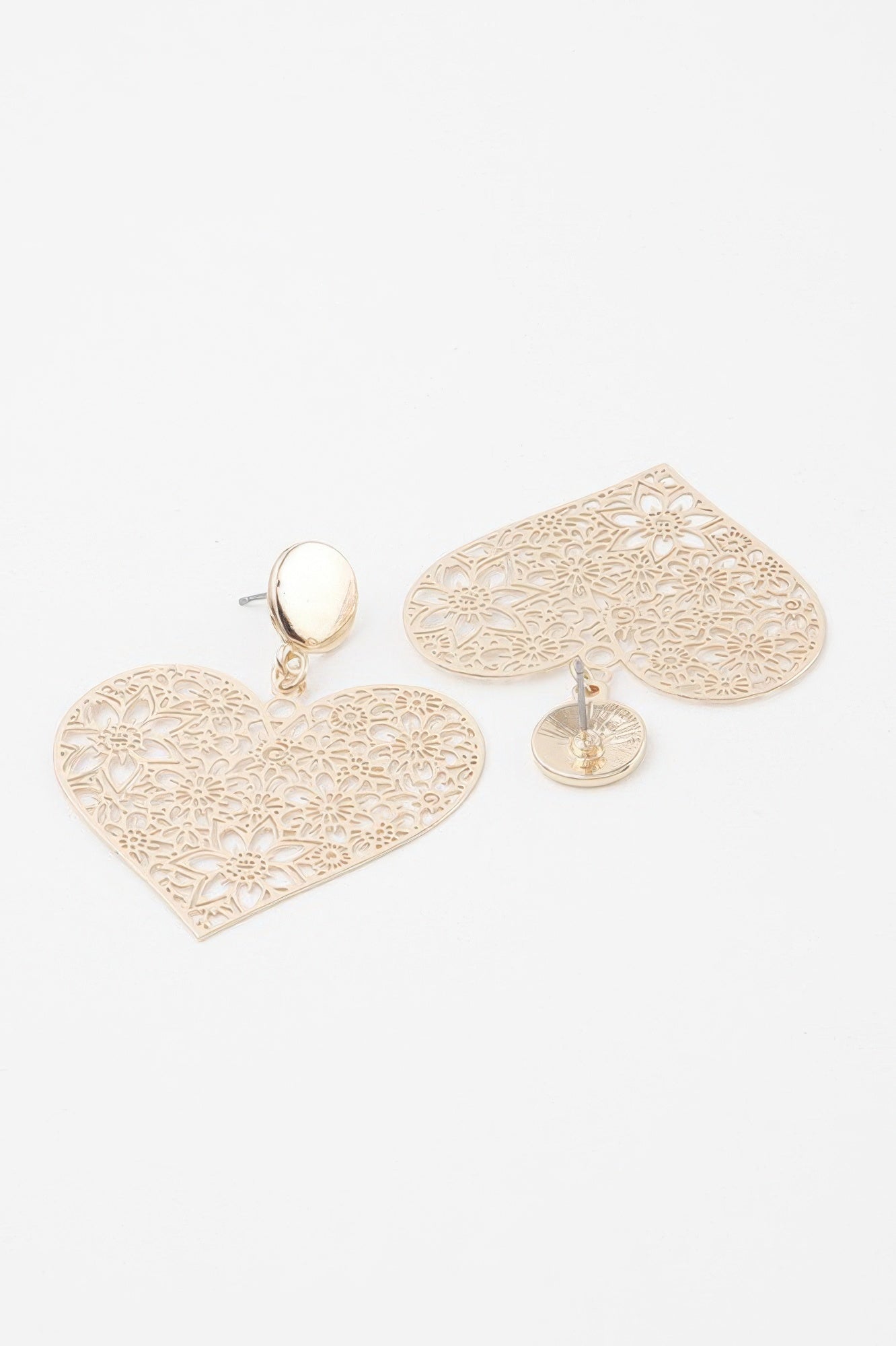 Gold heart-shaped filigree lace earrings dangling from round stud posts