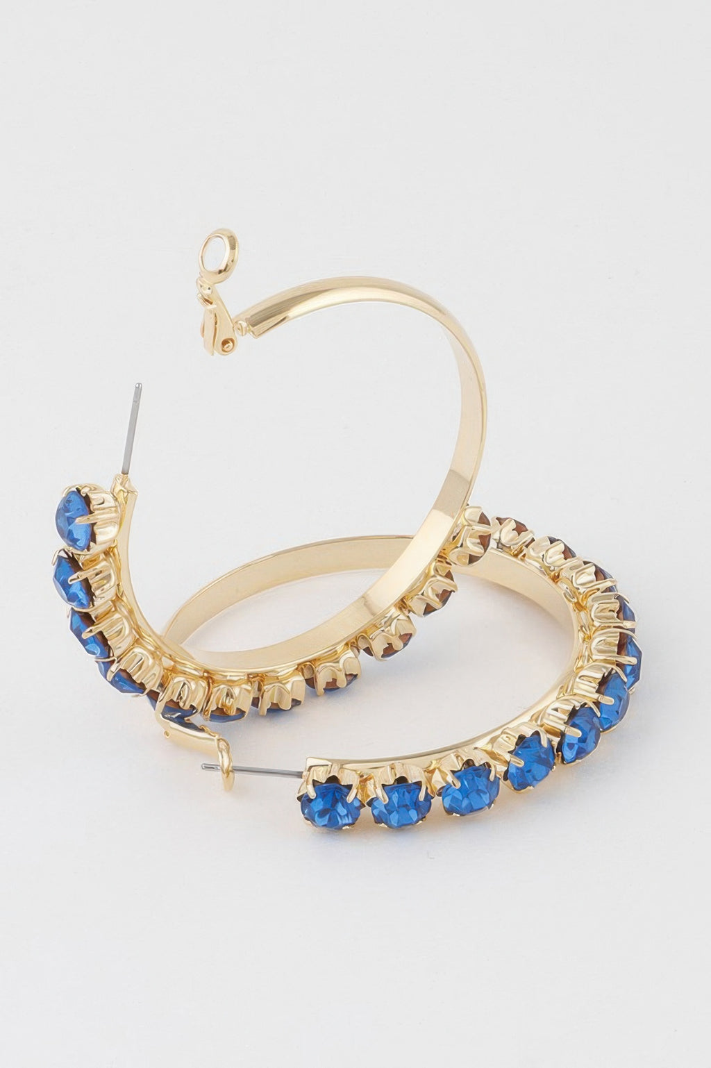 Gold half-hoop earrings with blue crystal row, hinged clasp visible