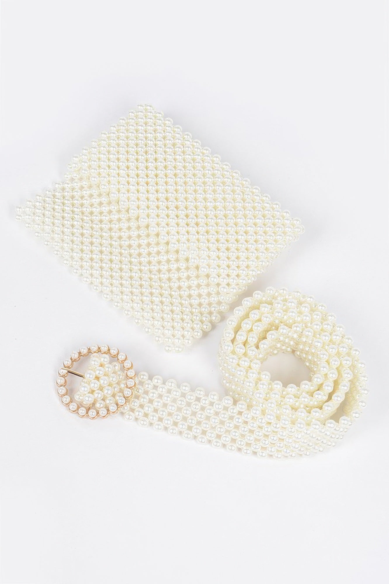 Ivory faux pearl belt bag, heart buckle and looped beaded strap on flat lay