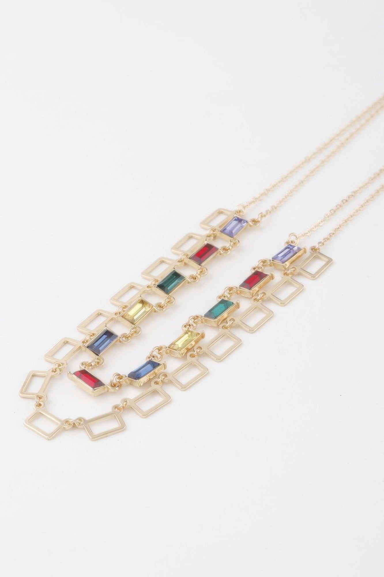 Close-up: gold-tone square crystal charm links with multicolor inset stones