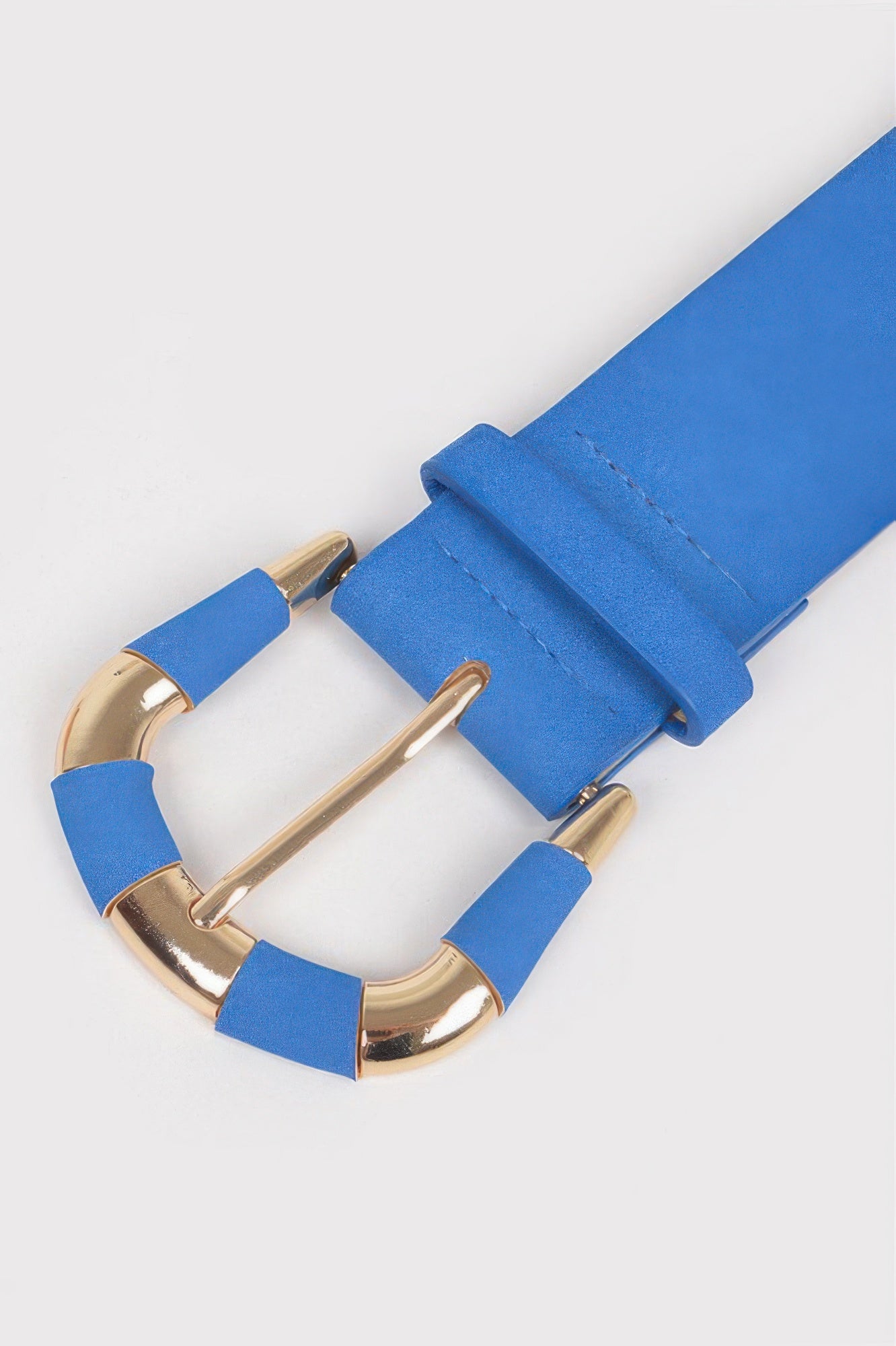 Close-up of cobalt blue micro suede belt with gold-tone buckle prongs