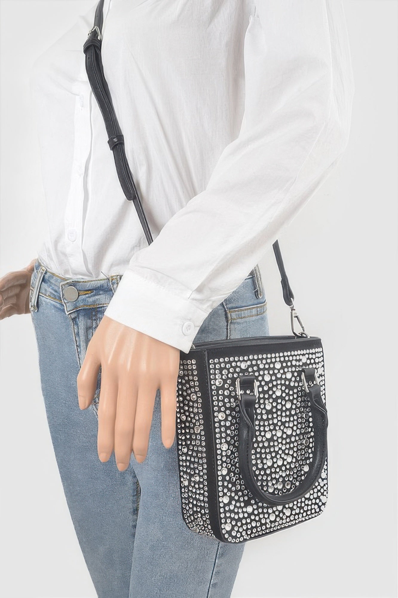 Hotfix crossbody bag worn on shoulder: black rhinestone stud pattern and small front pocket
