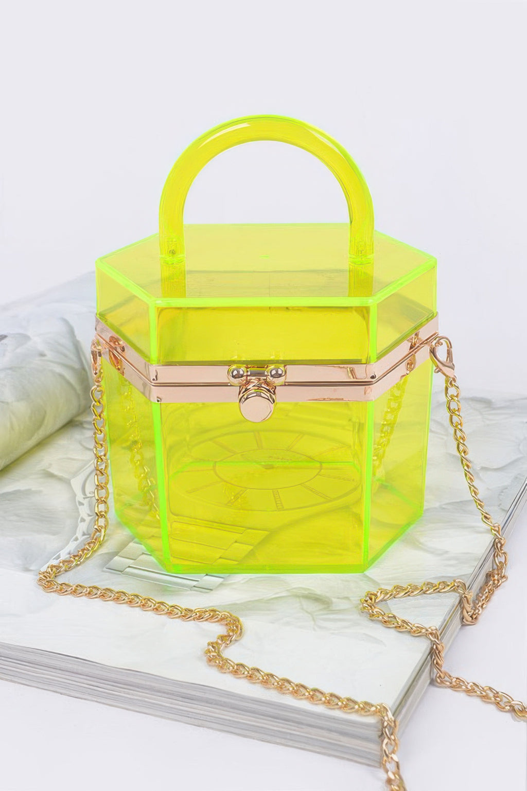 Translucent yellow hard mini clutch with hinged front clasp and gold chain strap