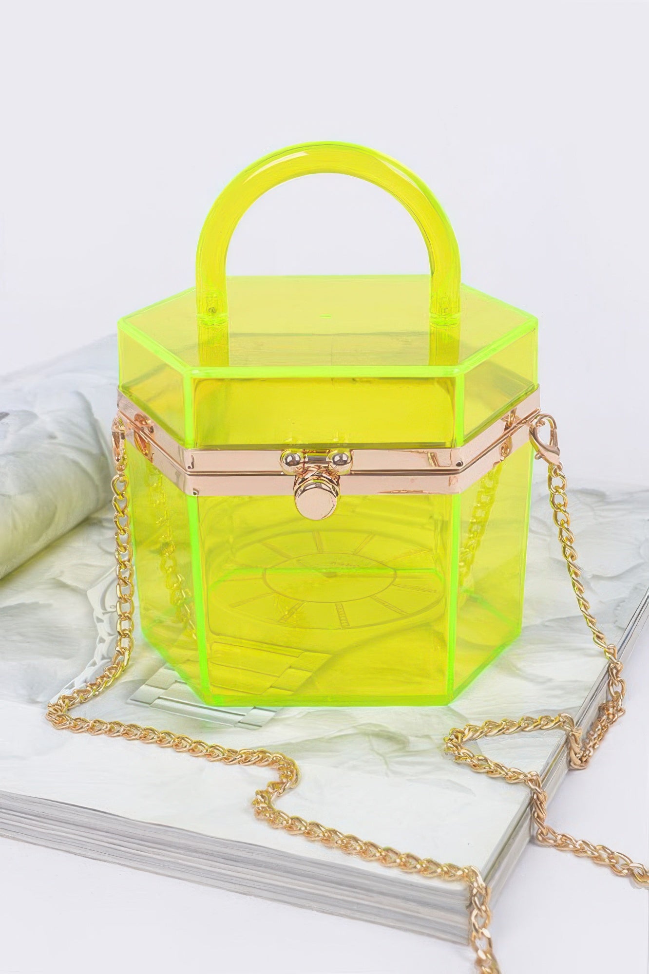 Translucent yellow hard mini clutch with hinged front clasp and gold chain strap