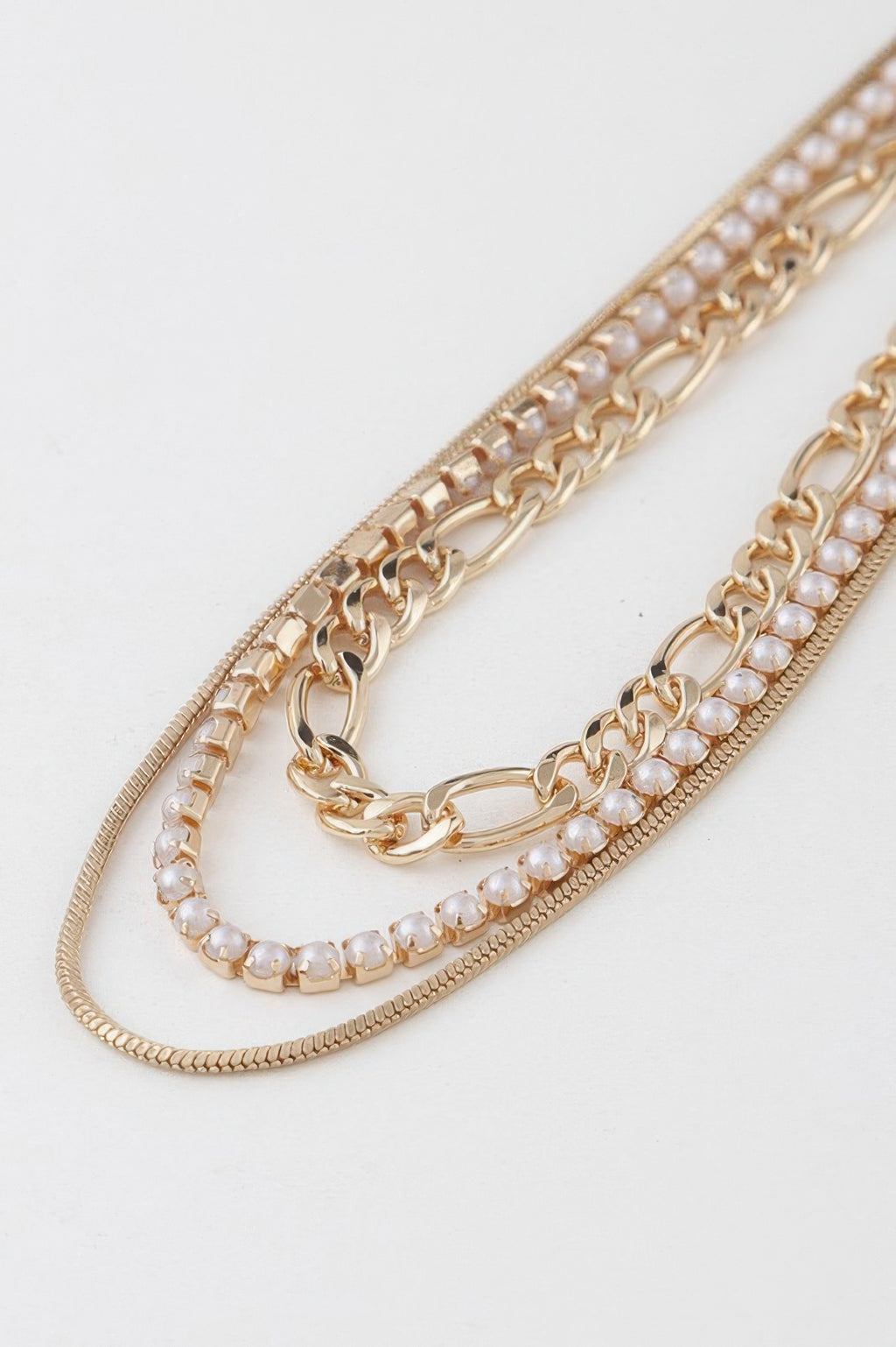 Close-up of gold chain with small faux-pearl beads and sparkle link accents