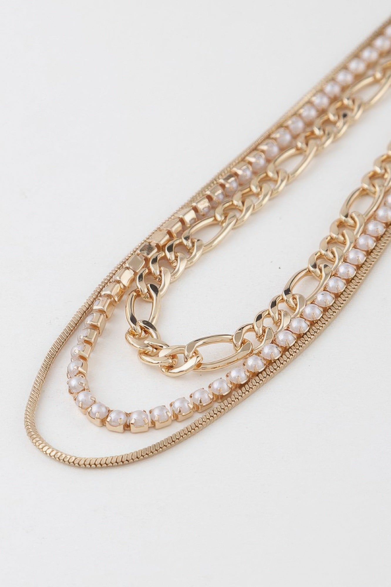 Close-up of gold chain with small faux-pearl beads and sparkle link accents