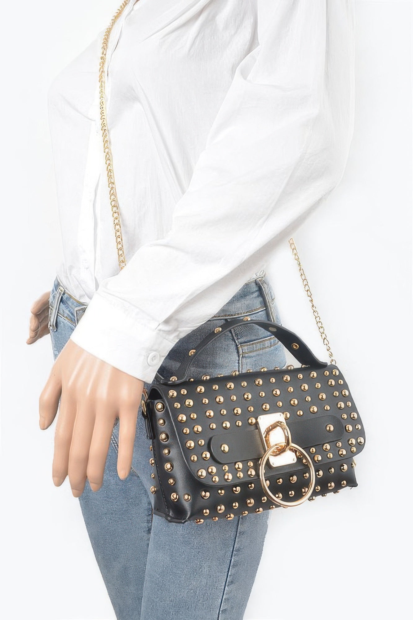 Black studded mini bag worn crossbody with gold-tone studs and ring clasp