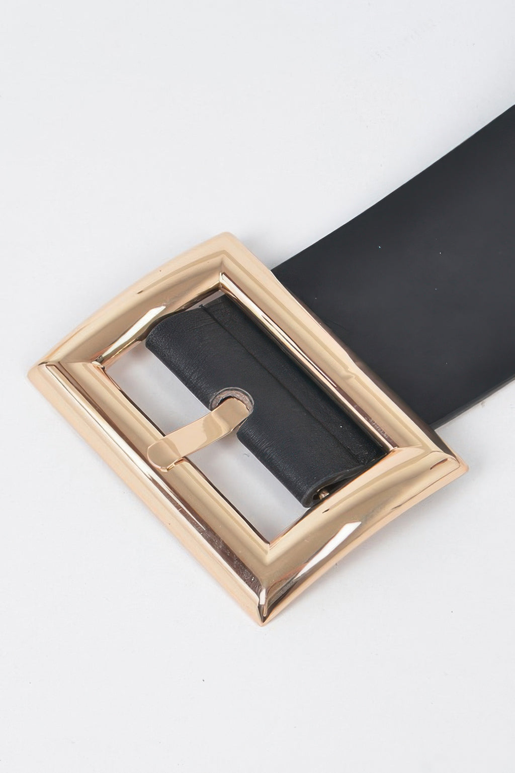 Gold-tone rectangular buckle close-up on black belt strap