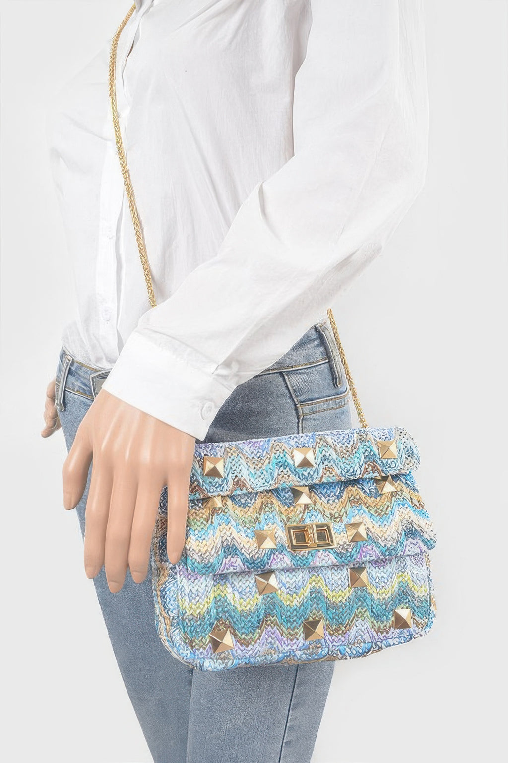 Blue chevron faux straw flap bag worn crossbody with gold chain strap and stud detailing