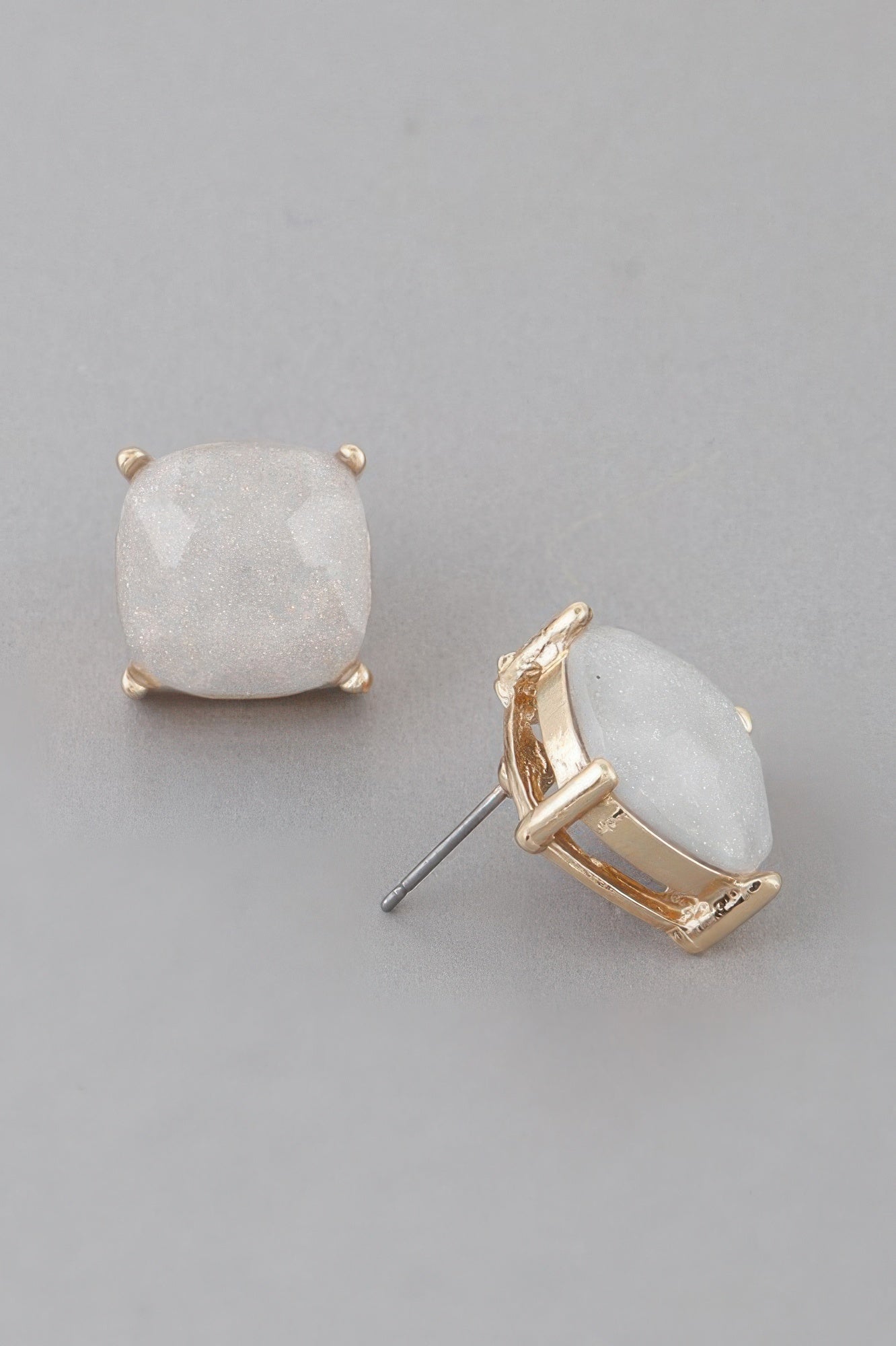 Luxury square stud earrings, gray cushion-cut stone with gold-tone bezel and posts.