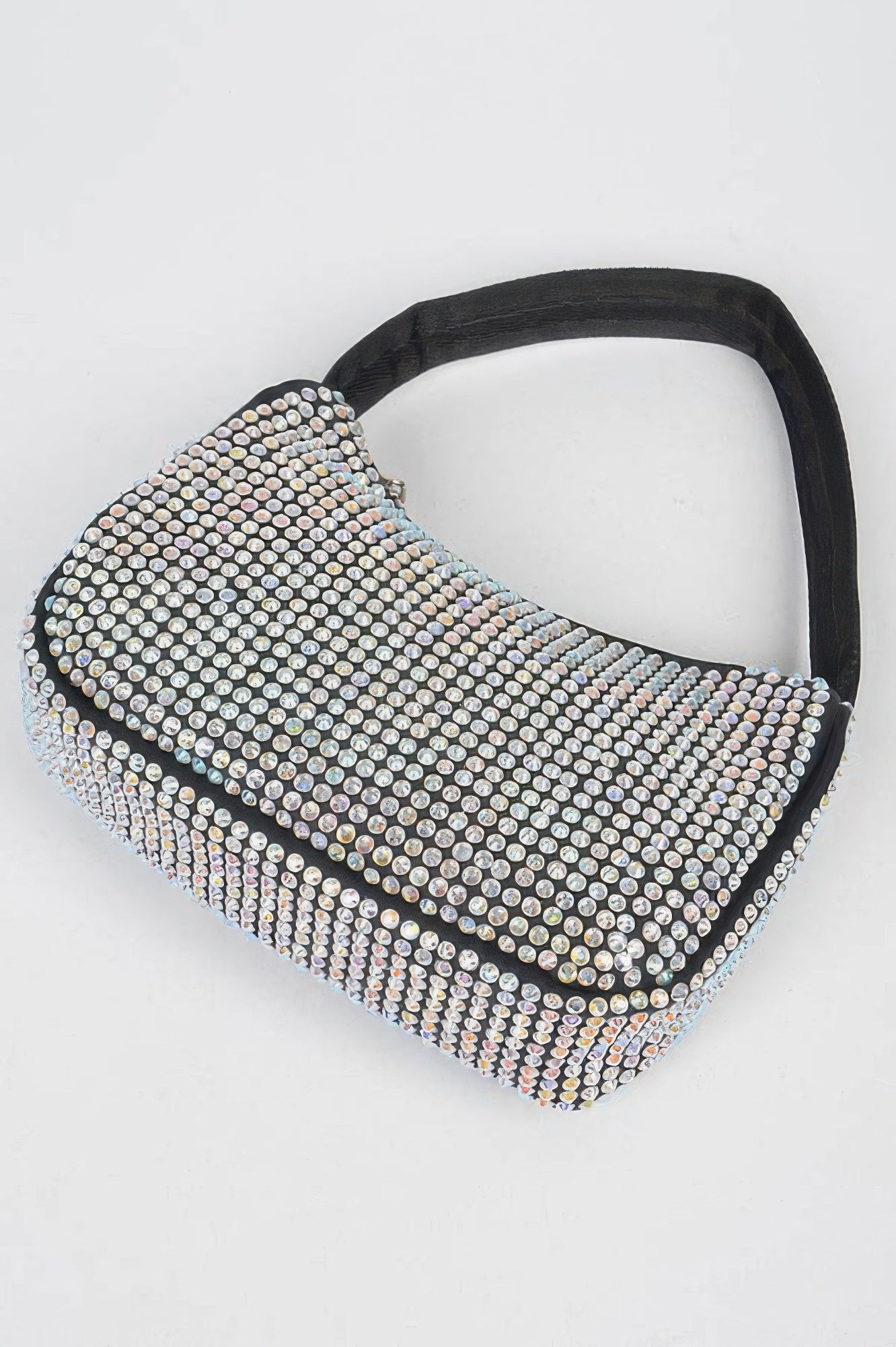 Black rhinestone shoulder bag with slanted silhouette, zip top, and curved handle