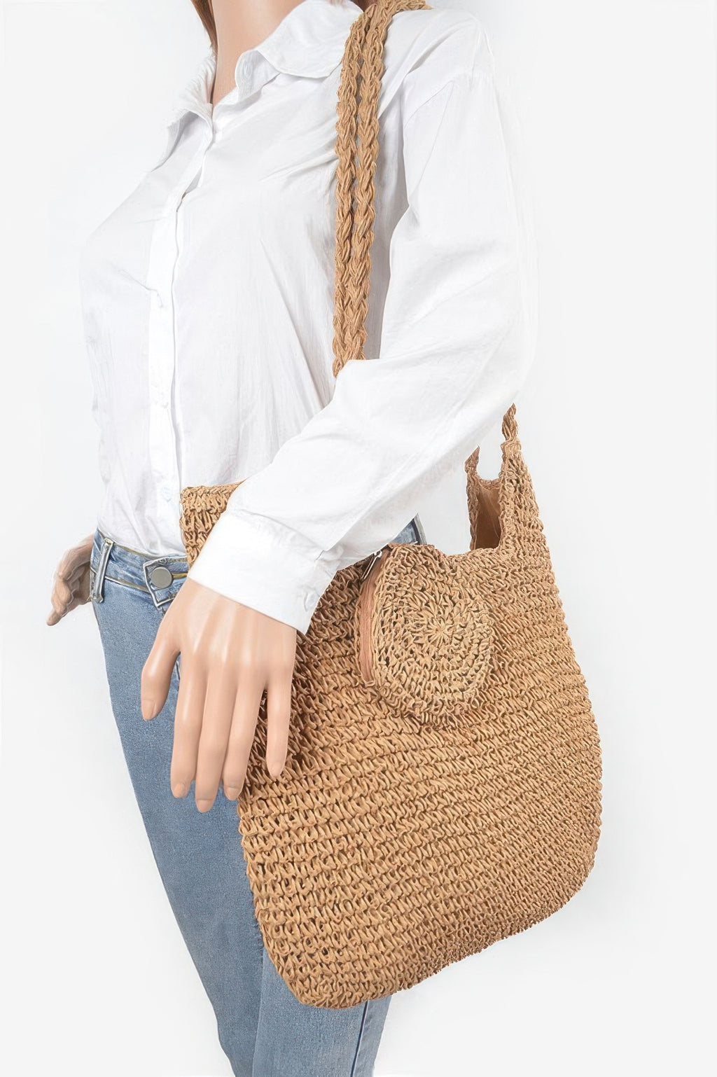Khaki faux straw tote bag carried by model, rope handles and textured body
