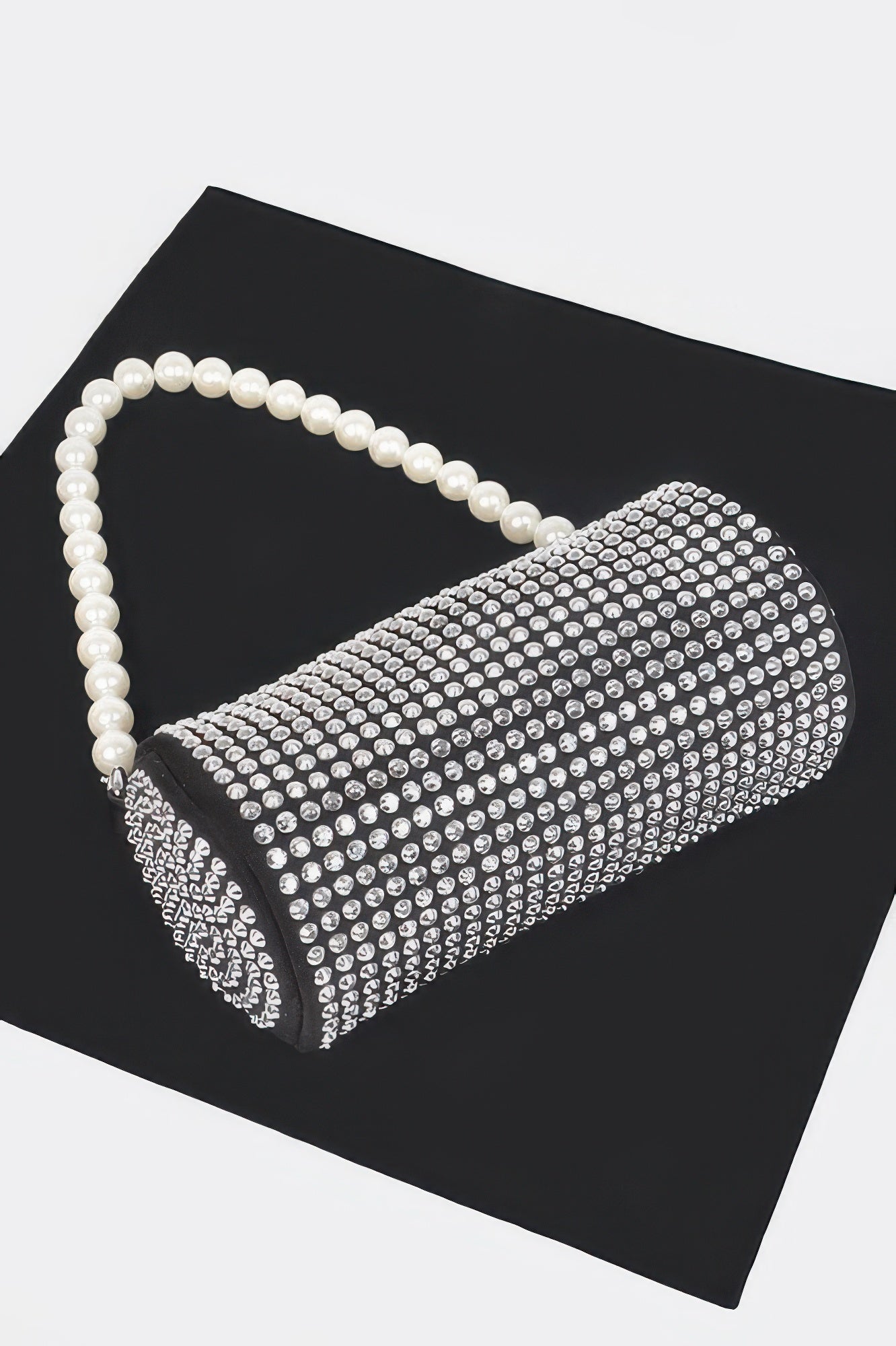Black tube bag with all-over rhinestone mesh and pearl shoulder handle.