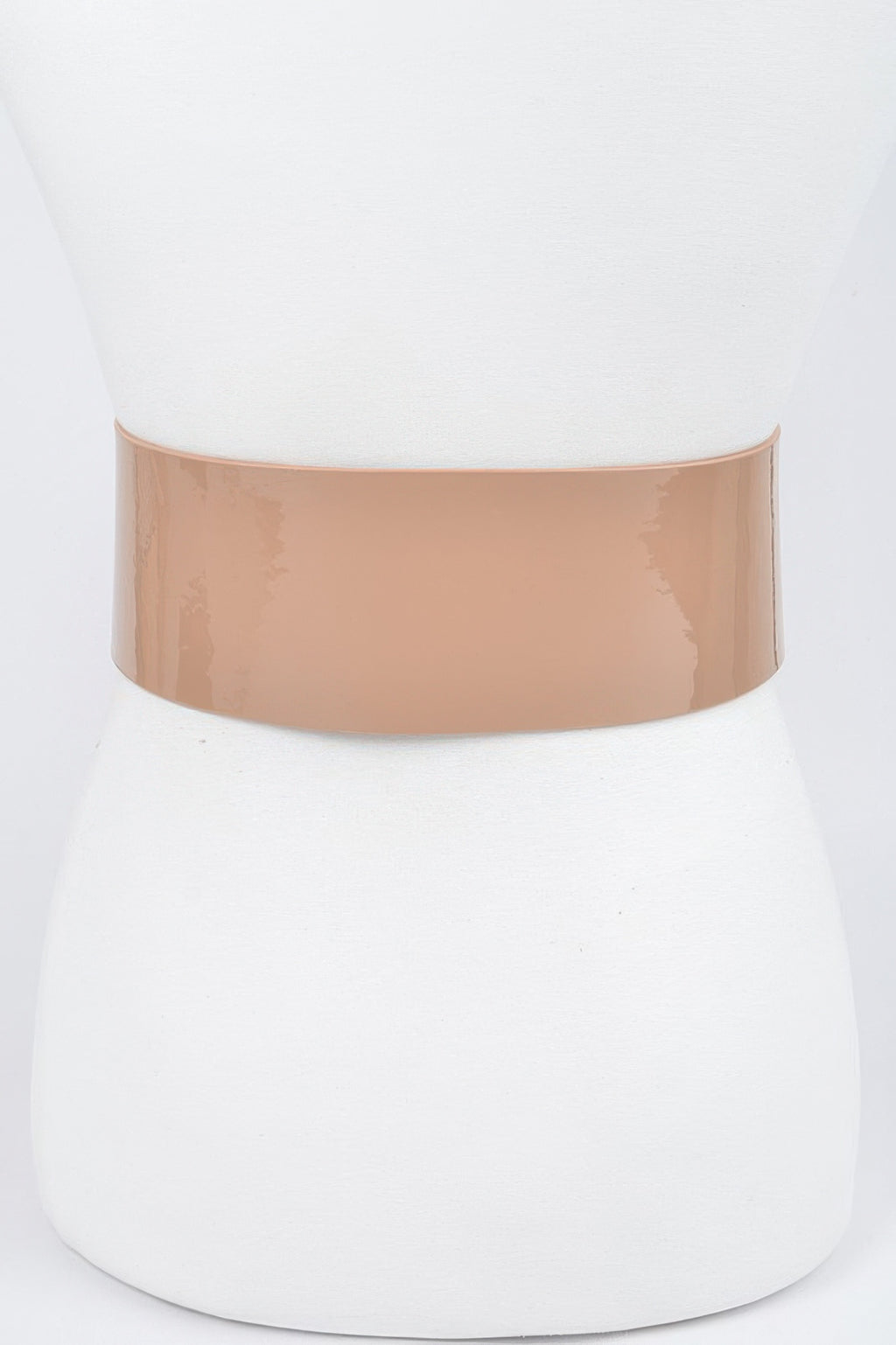 Oversized waist belt: wide nude enamel strap with round edge and grommet holes.