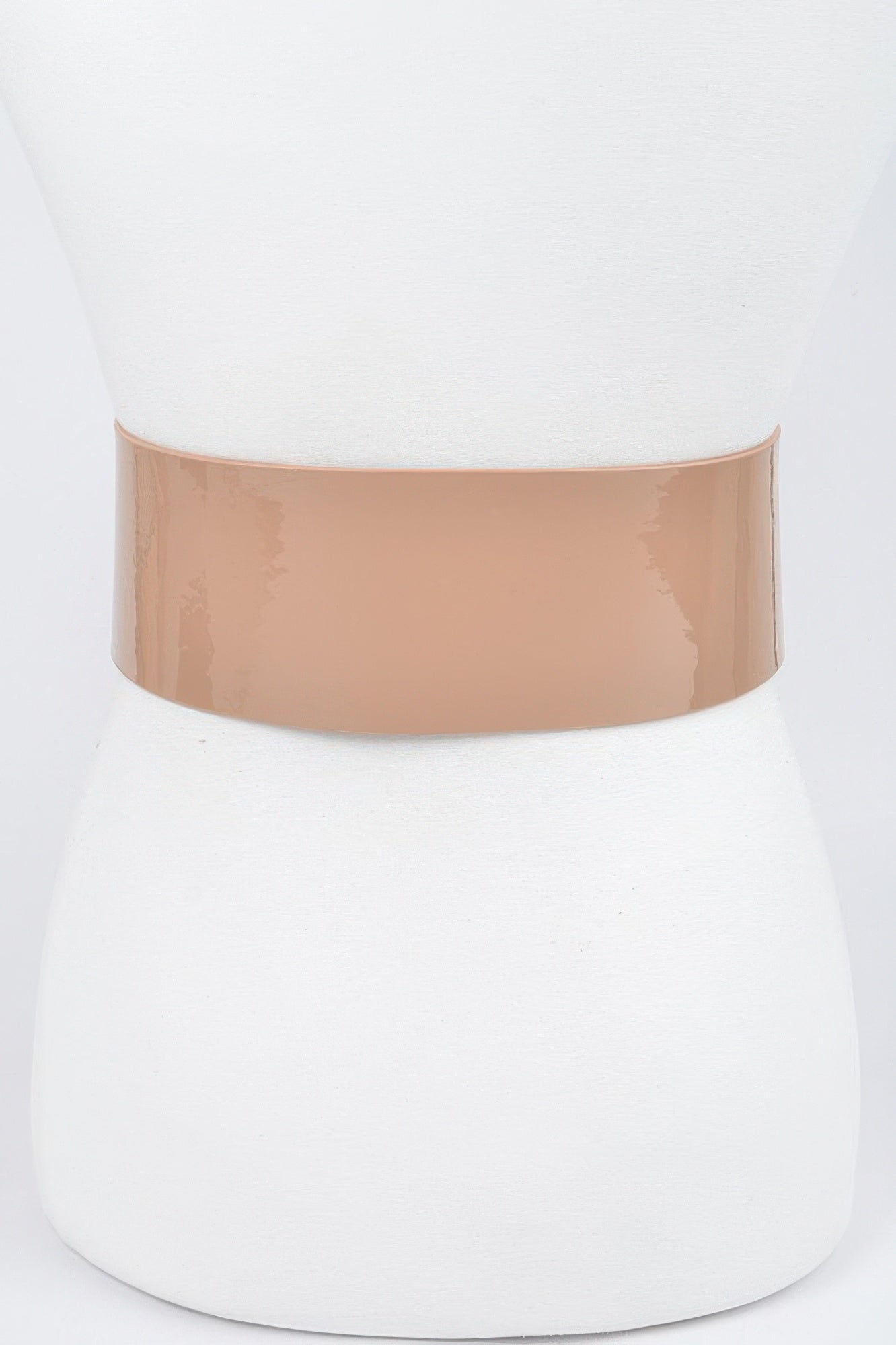 Oversized waist belt: wide nude enamel strap with round edge and grommet holes.