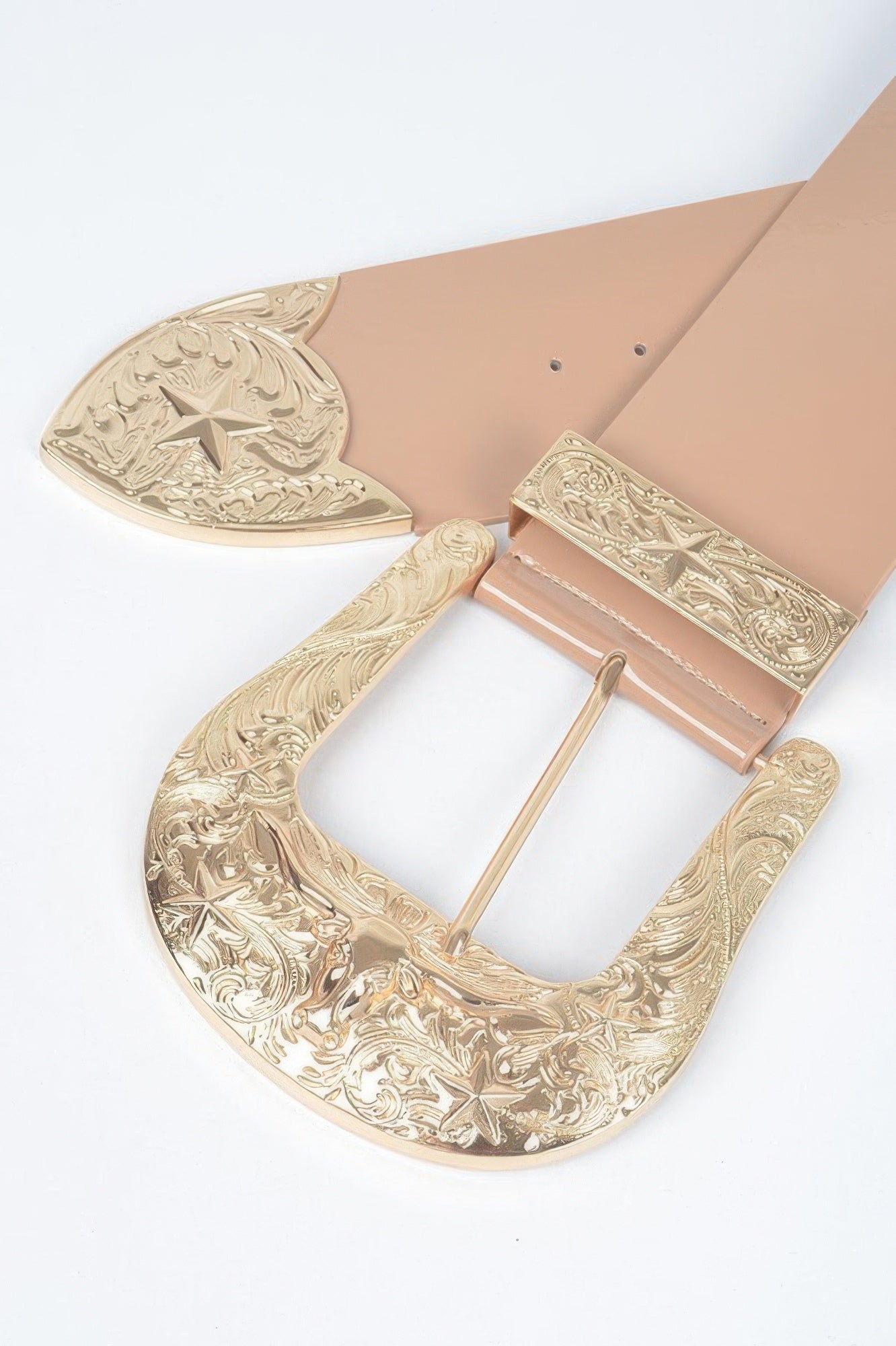 Oversized waist belt close-up: nude strap with gold engraved buckle and star motif.